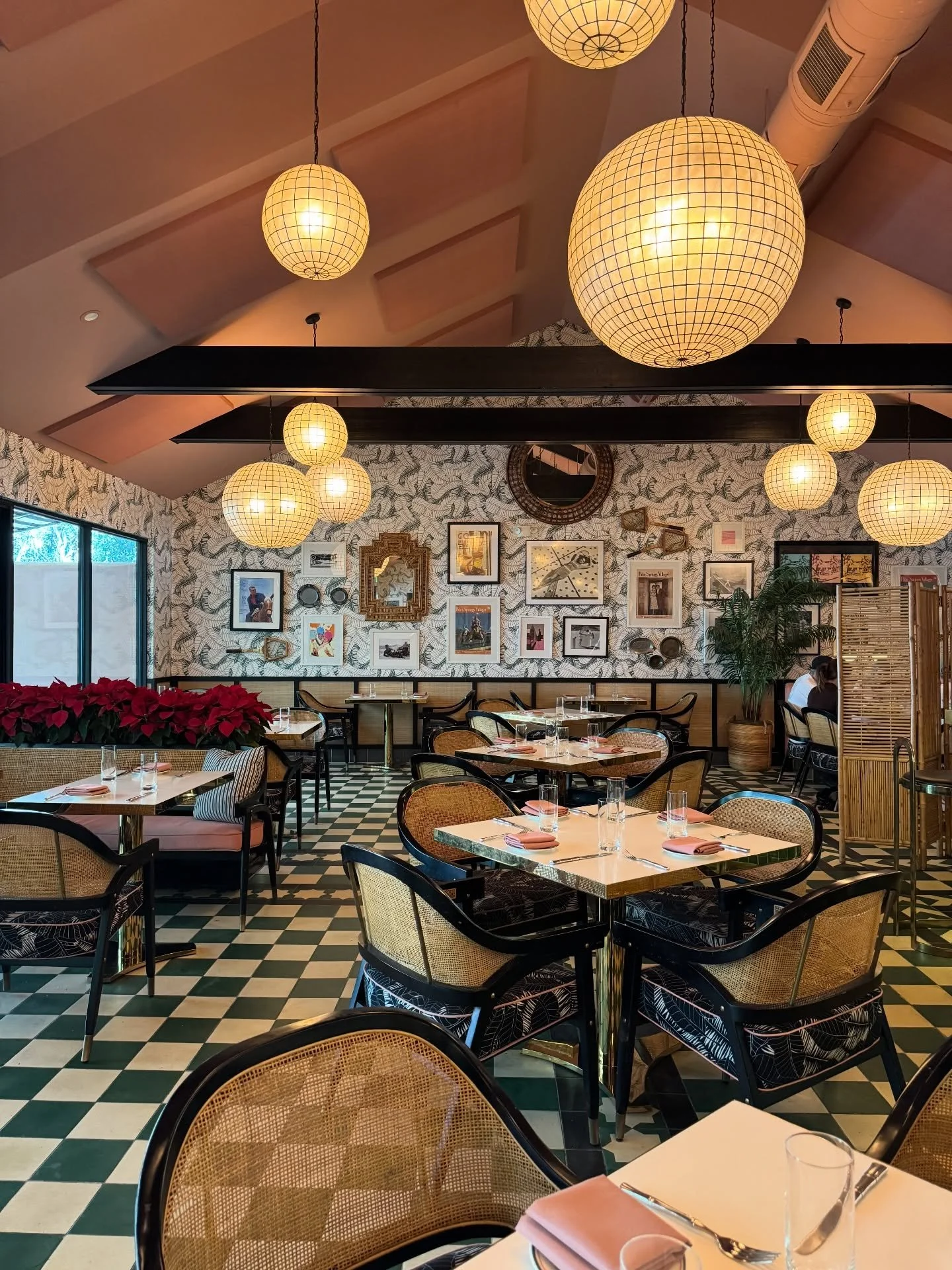 Palm Springs restaurant with woven globe pendants, patterned walls, and a green-and-cream tile floor.