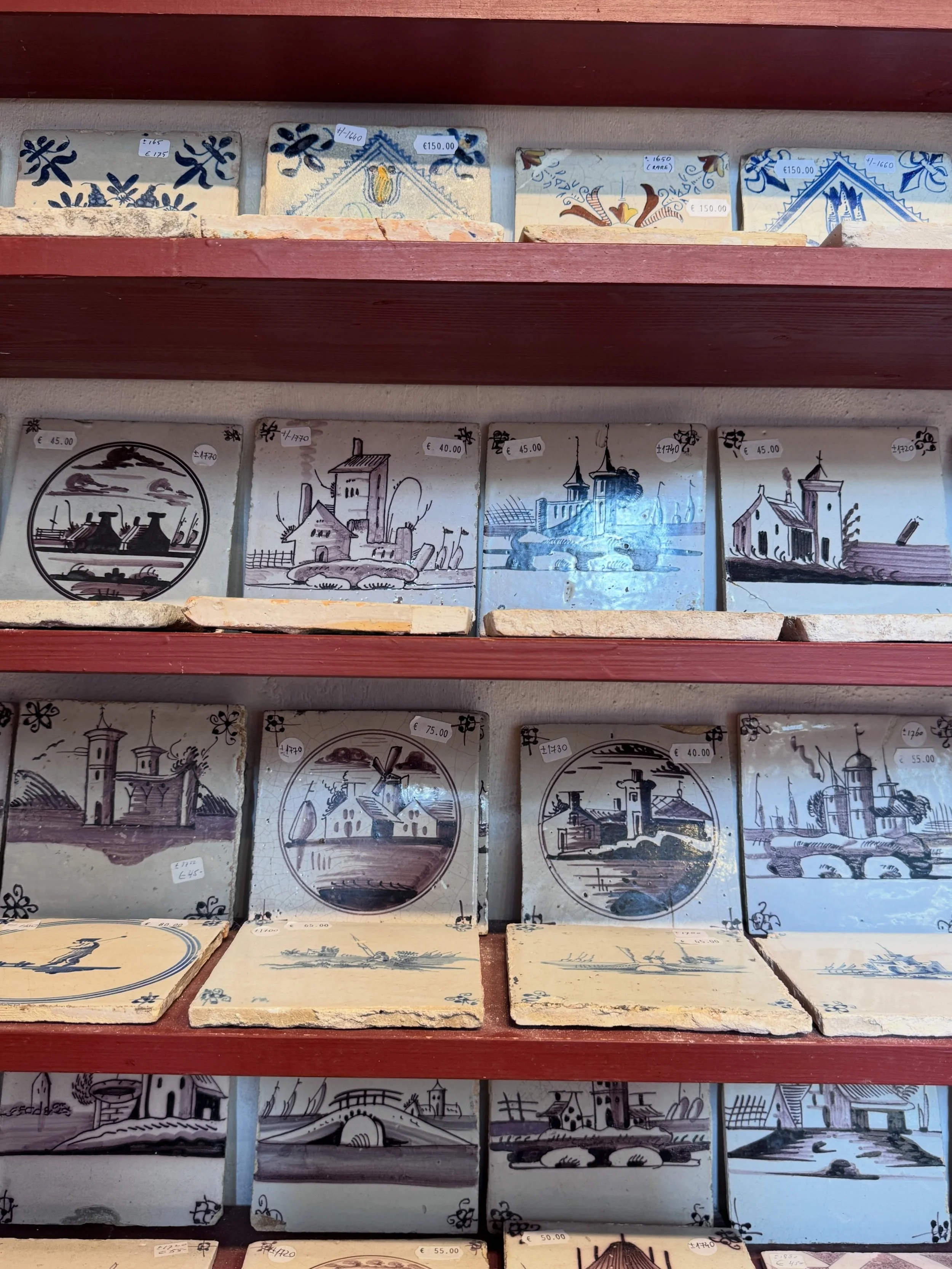 Hand-painted Delft tiles arranged on shelves, with landscapes and traditional figures.