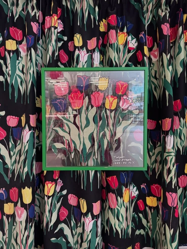 Black tulip-print textile with a green-framed floral artwork at Svenskt Tenn.