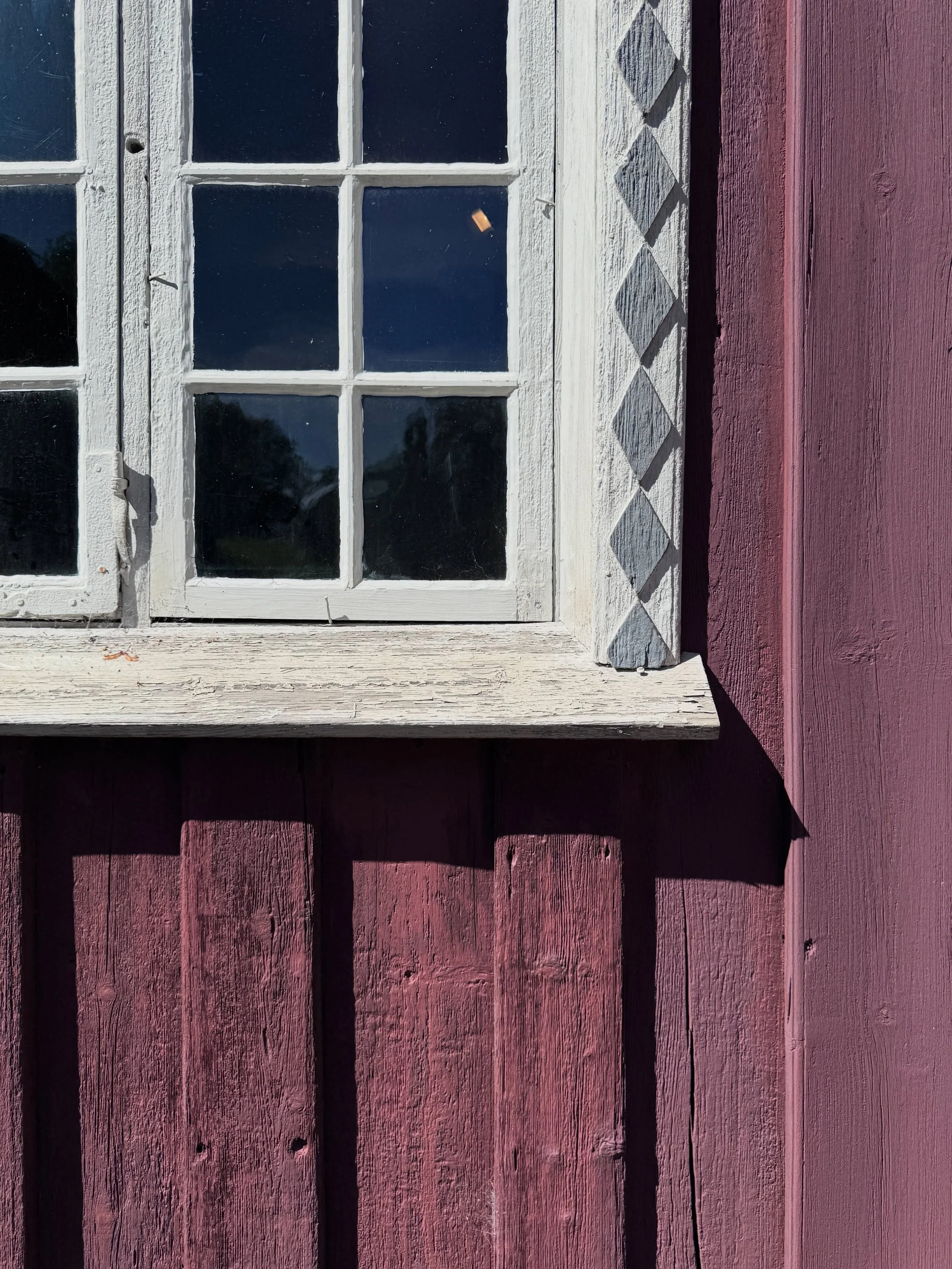 White-painted window in a red timber wall in Oslo.