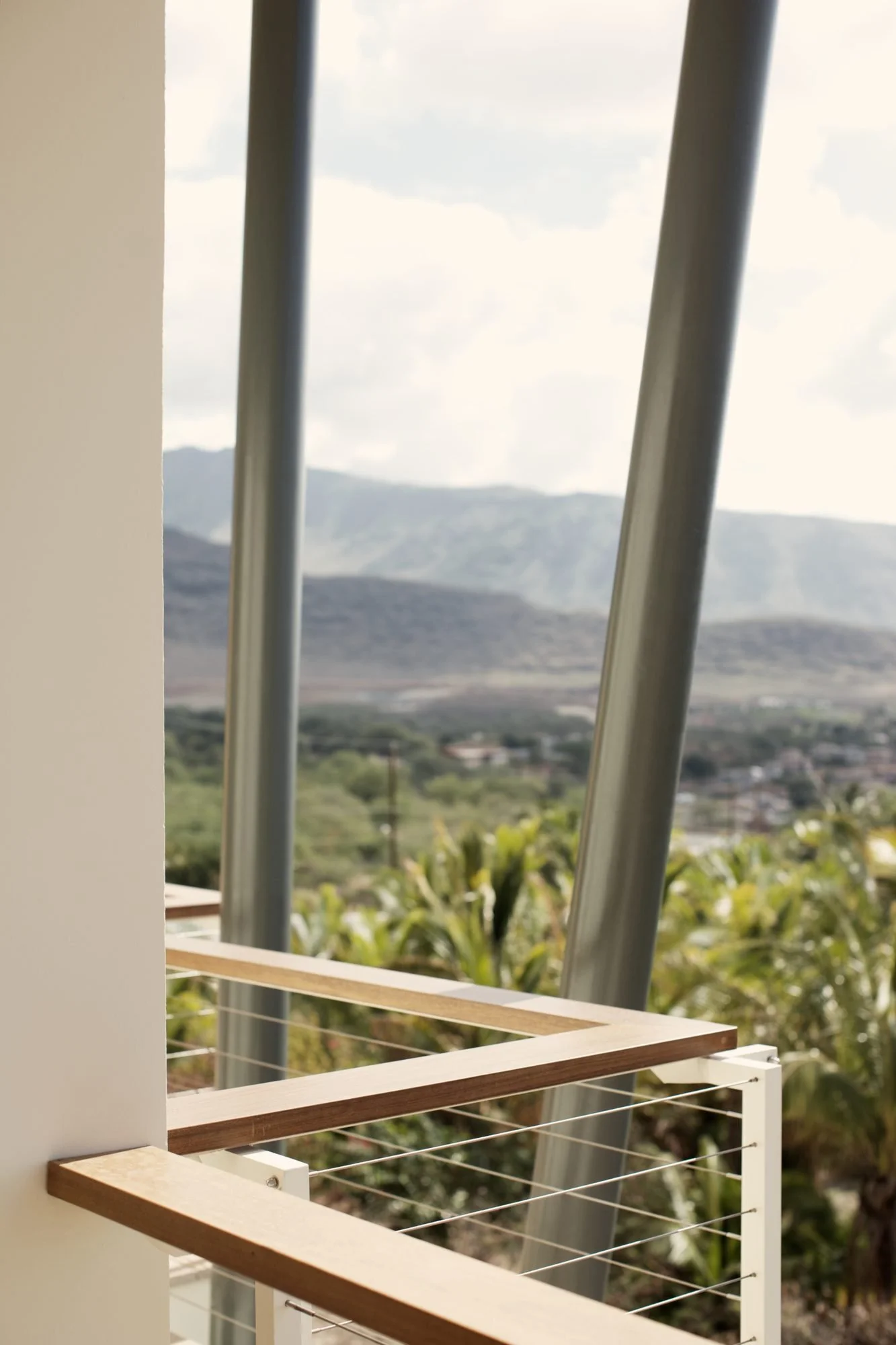 Wood-capped railing corner framing the valley and mountains