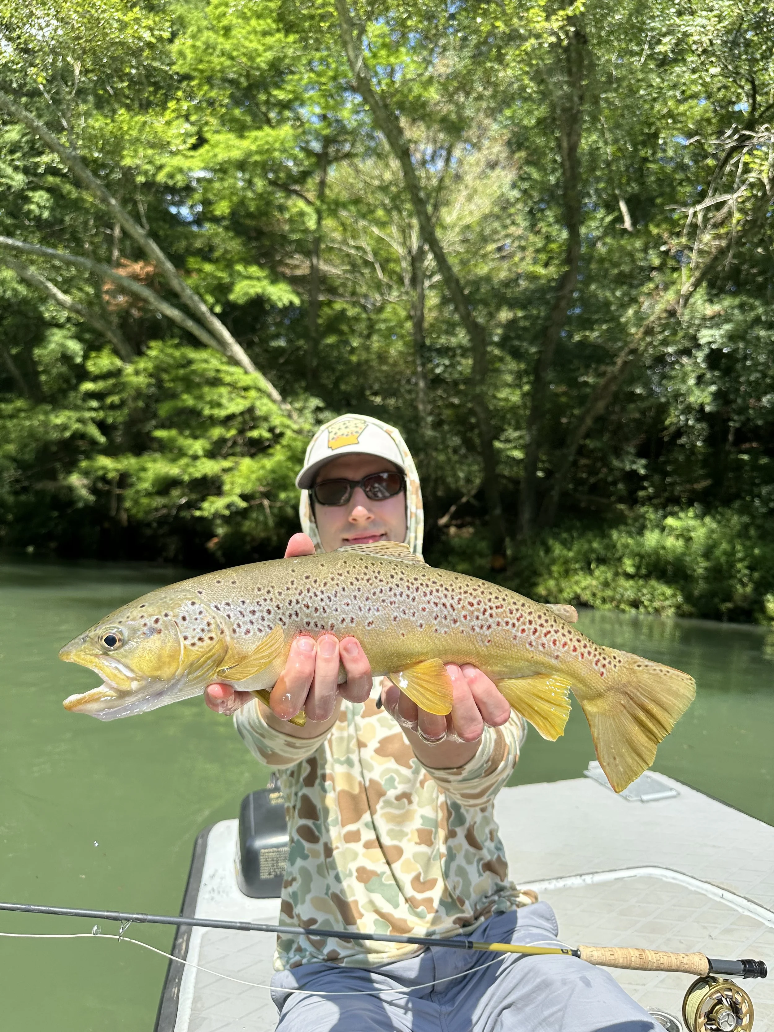 Angler holding a brown trout on a boat