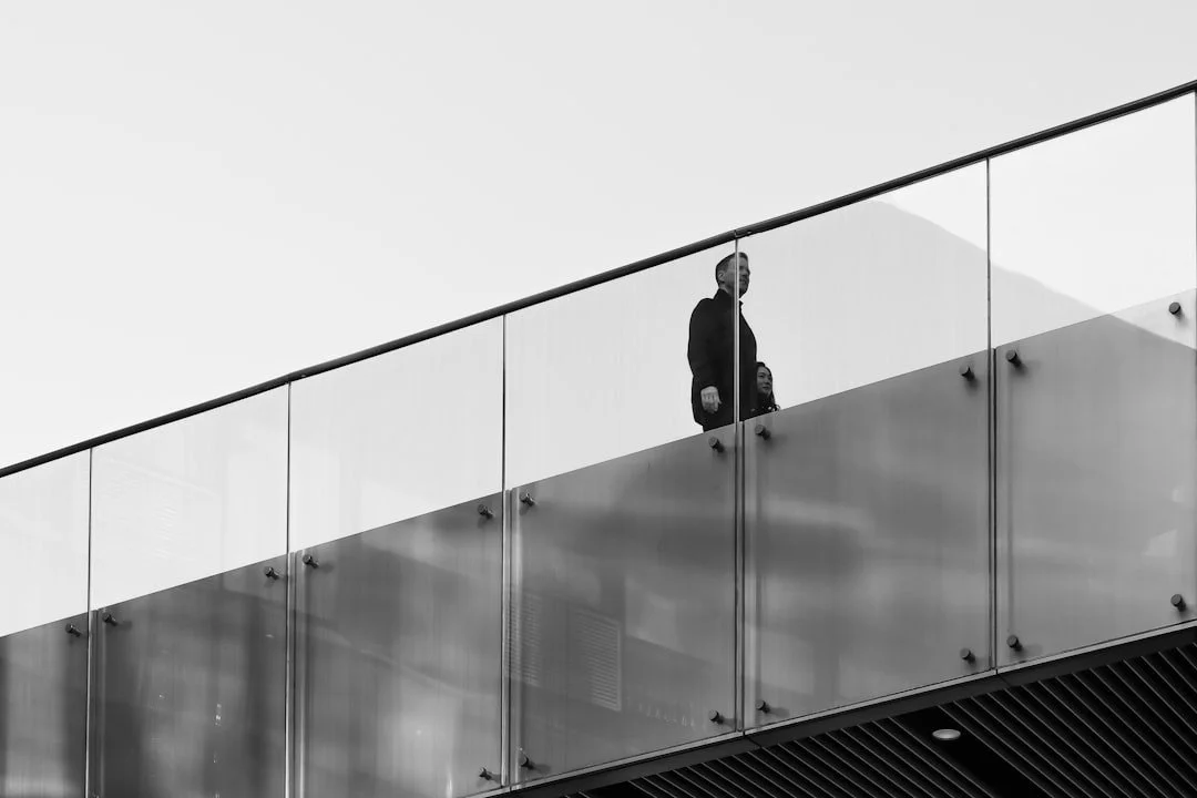 Senior professional walking through a modern glass corporate interior