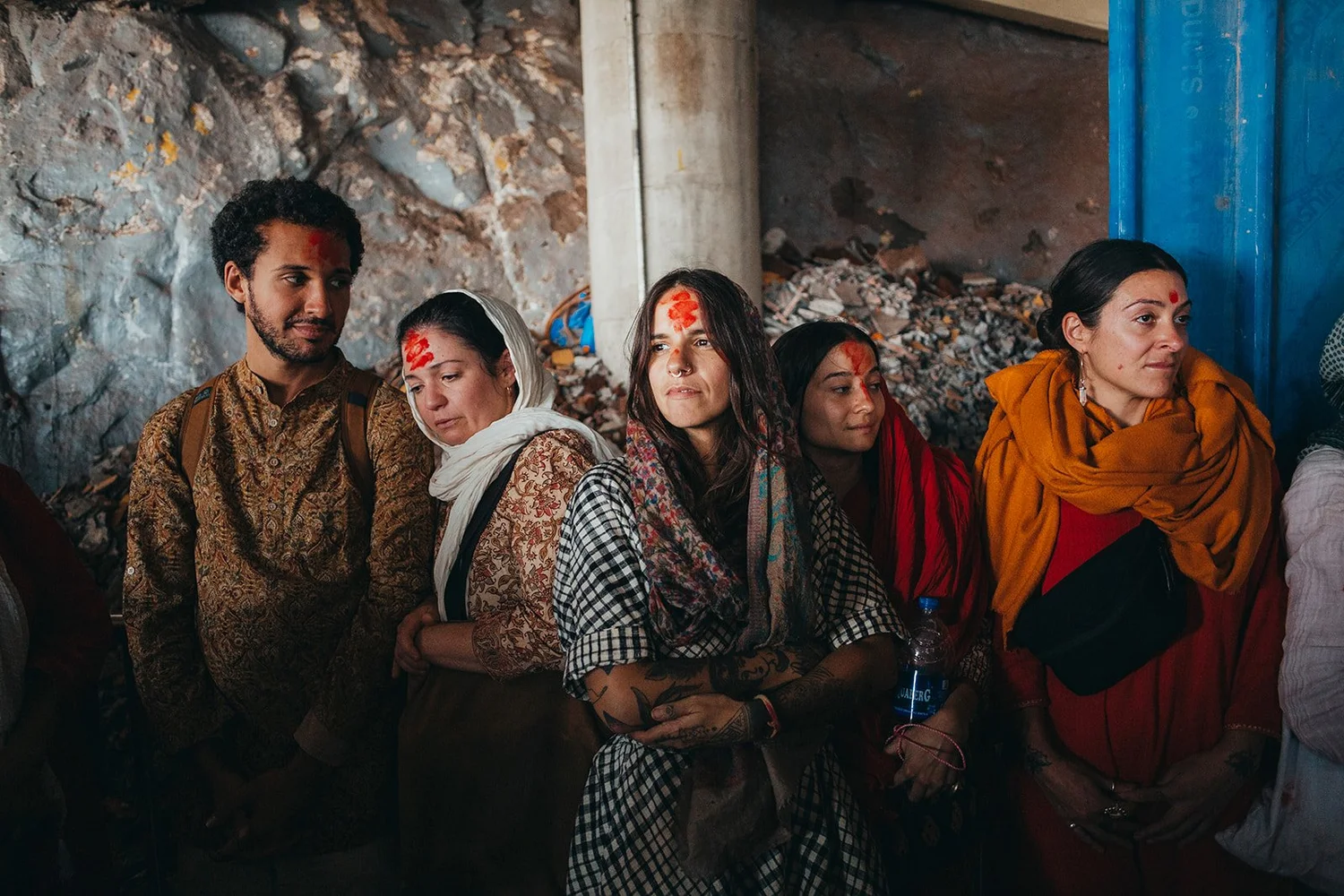 Body Temple pilgrims standing together in India with red kumkum marks on their foreheads, Adriana at the center