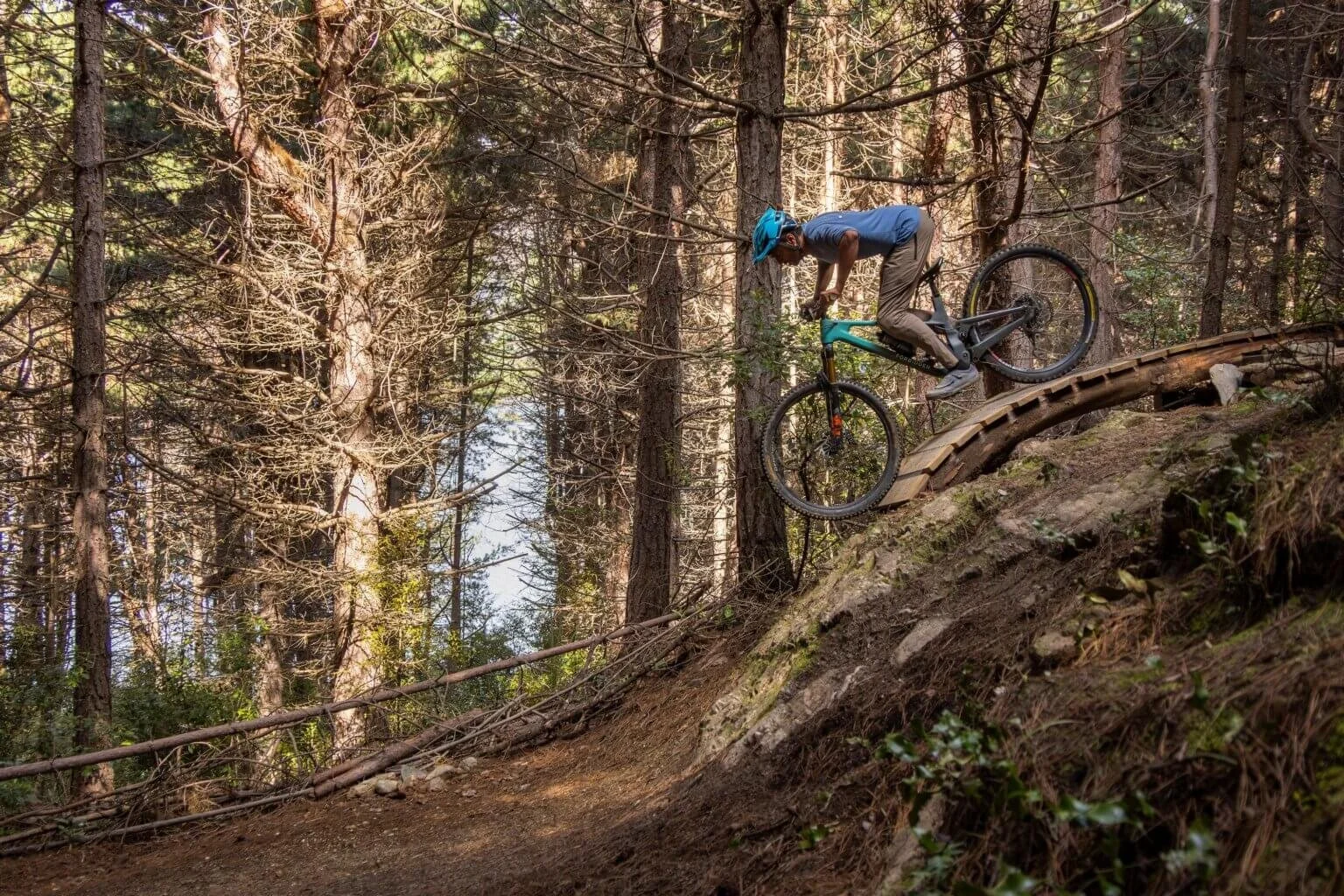 Rider moving lower and closer to the mountain bike on a steep feature