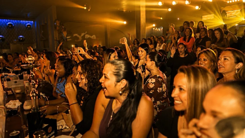 Women watching the show under gold light