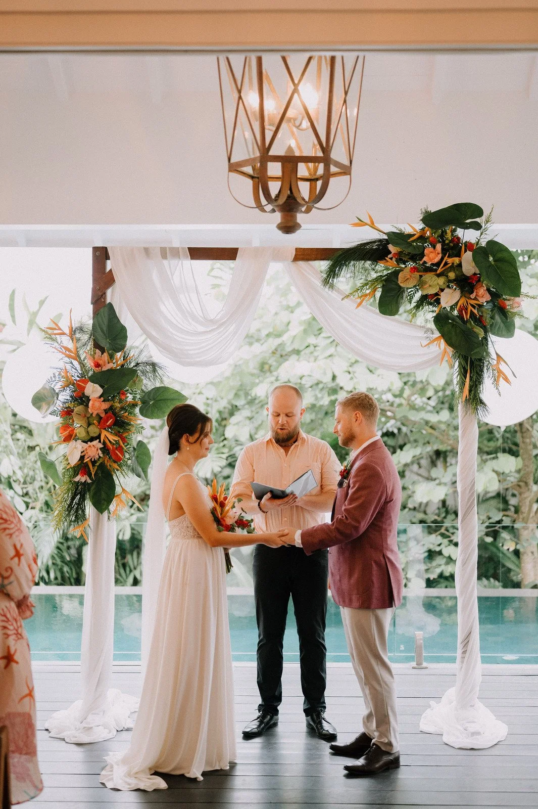 Ceremony beneath a tropical floral arch