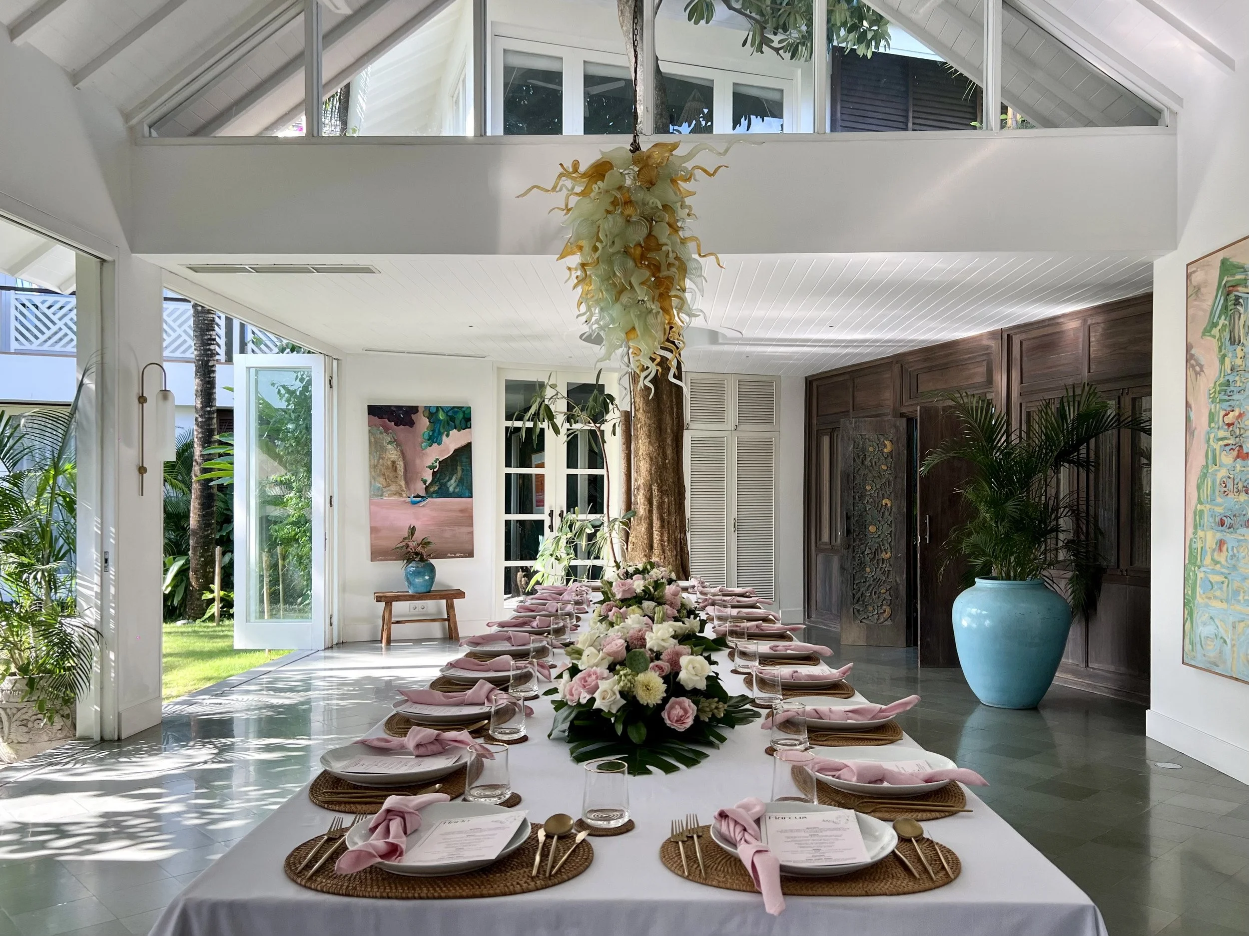 A wedding reception table with blush flowers and pink linen