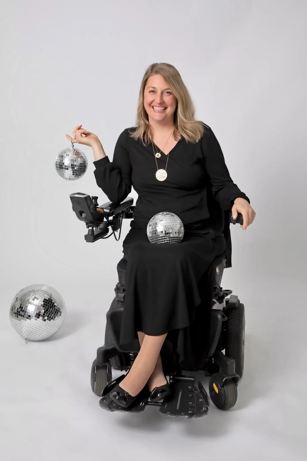 A model in a wheelchair poses with mirrored disco balls during an EQL Threads photo shoot