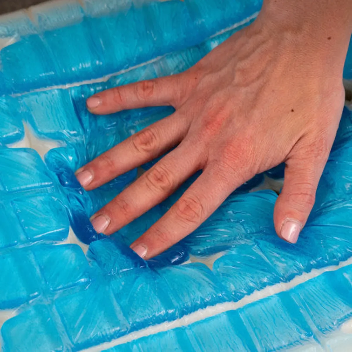 Close-up of a hand pressing the cooling Technogel head pillow on the Zecliner Model 2+ in Shell