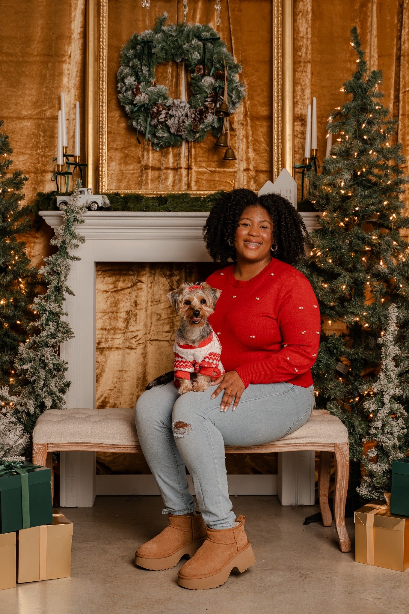Woman and her dog in a red sweater beside a Christmas tree