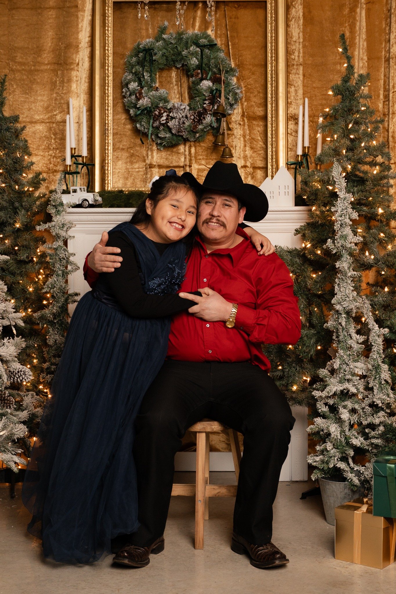 Woman and child together by a gold Christmas fireplace