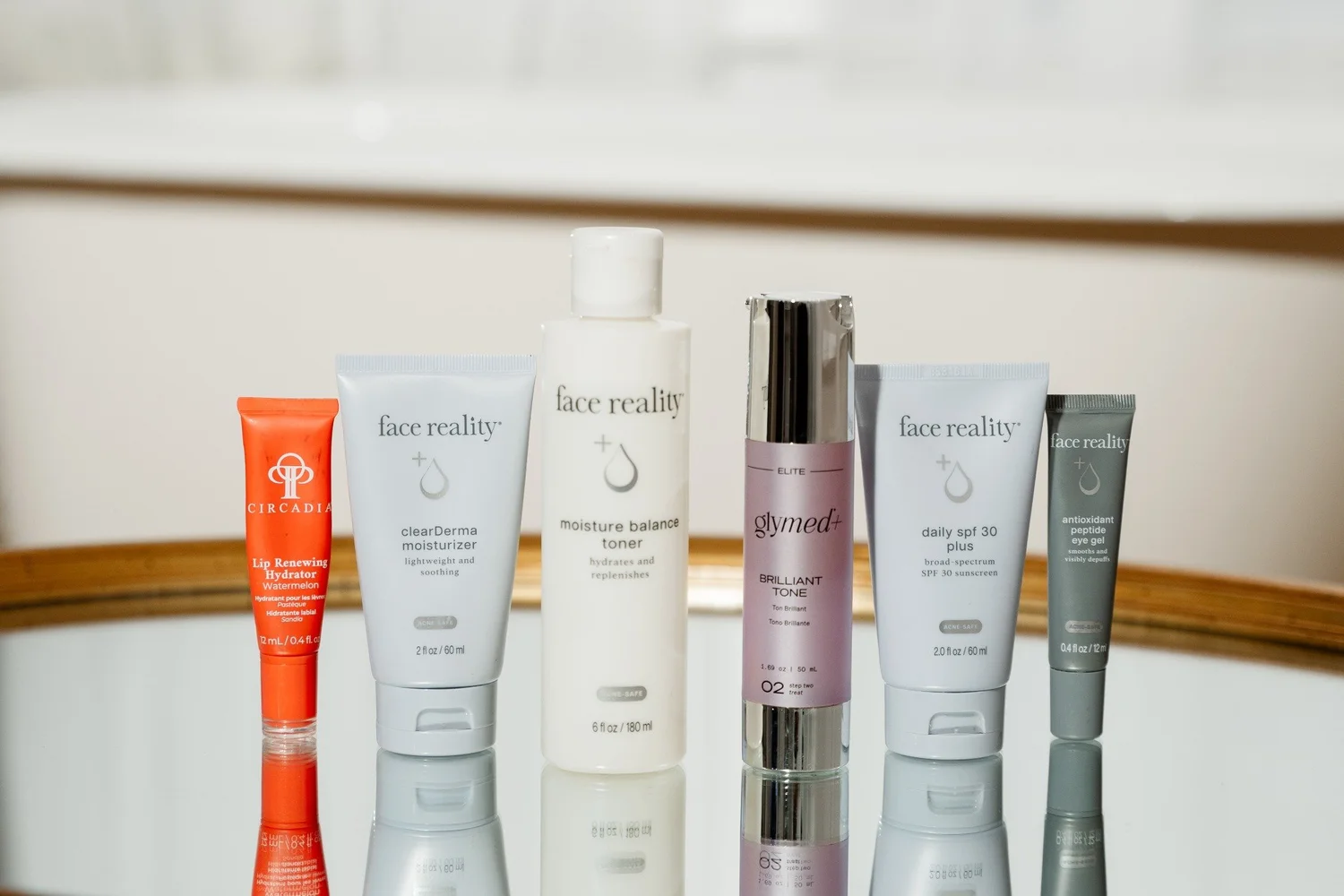 A collection of skincare products arranged on a white vanity.