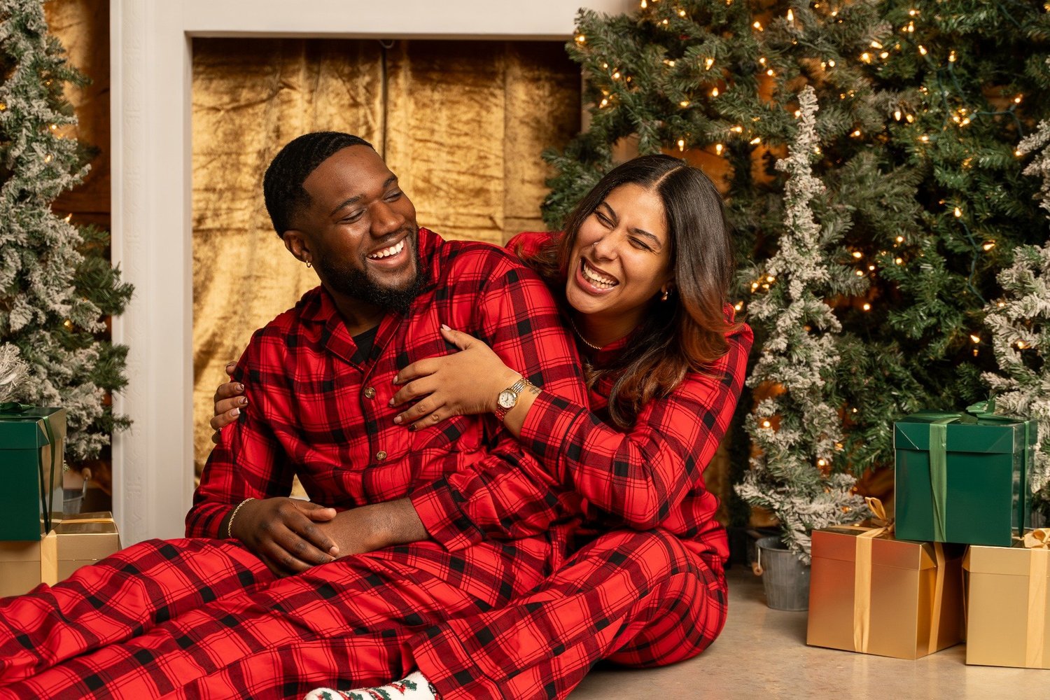 Couple laughing in matching red Christmas pajamas