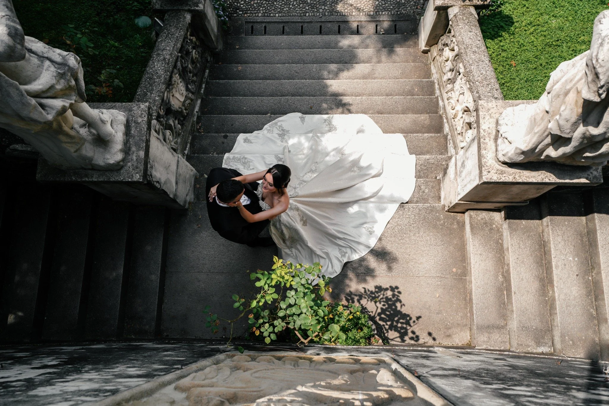 Bride and groom embracing on a stone staircase