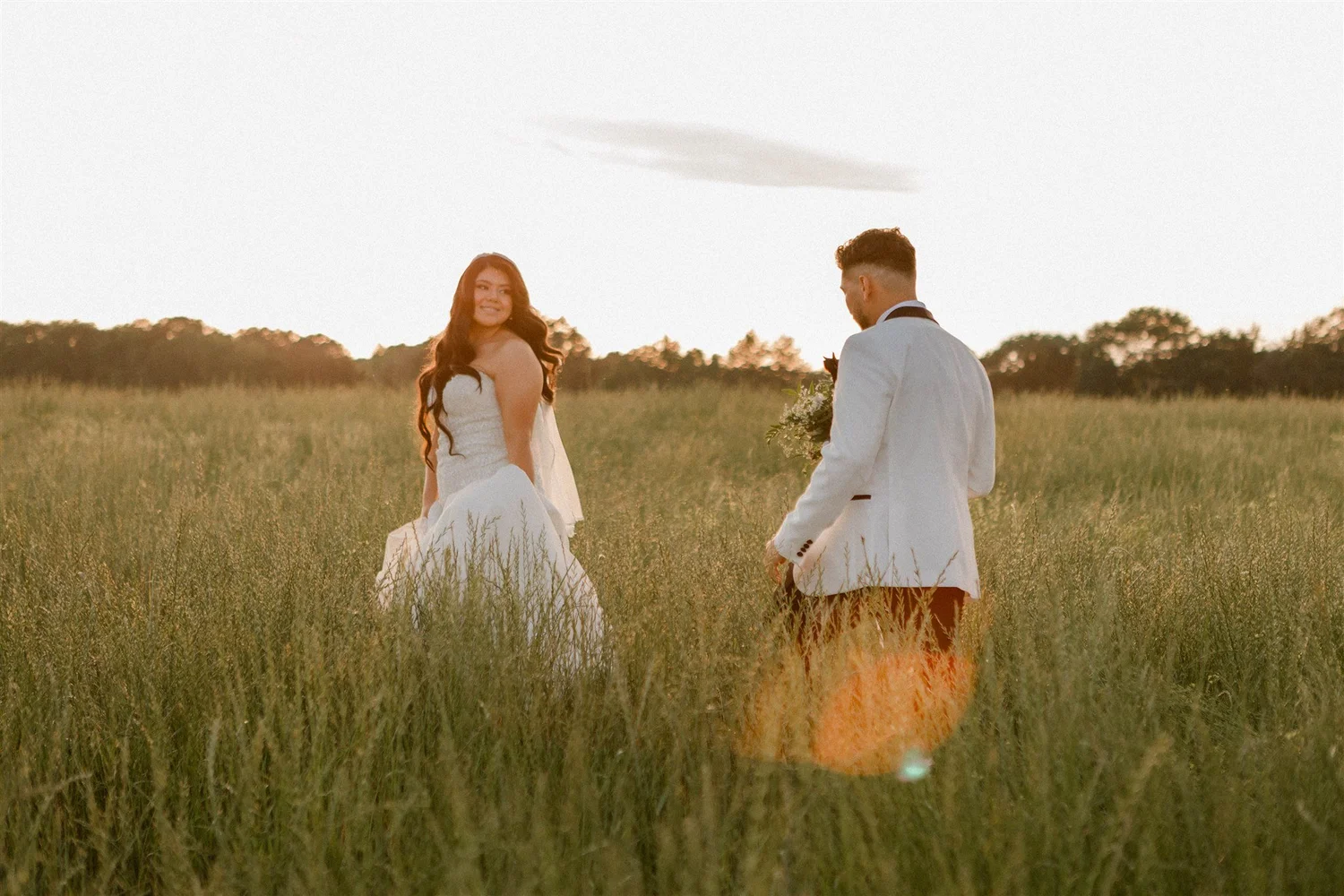A couple alone in an open field at golden hour
