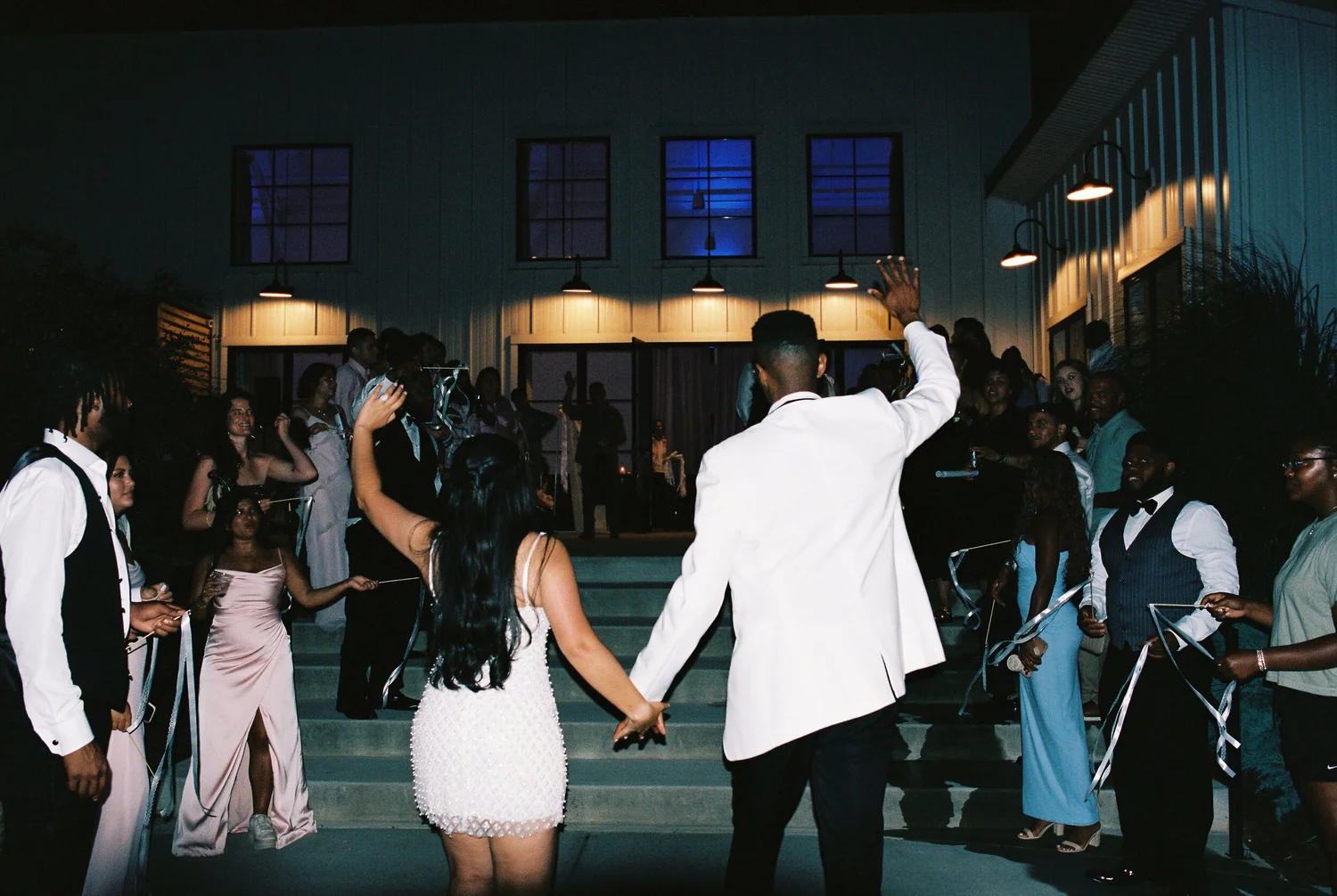 A couple running out through their guests at the end of the night, shot on 35mm film