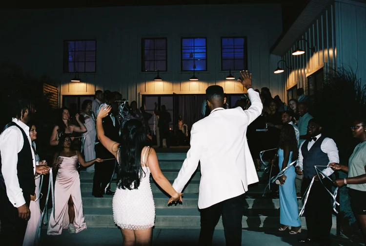 A couple celebrating with their guests at the end of the night, shot on 35mm film