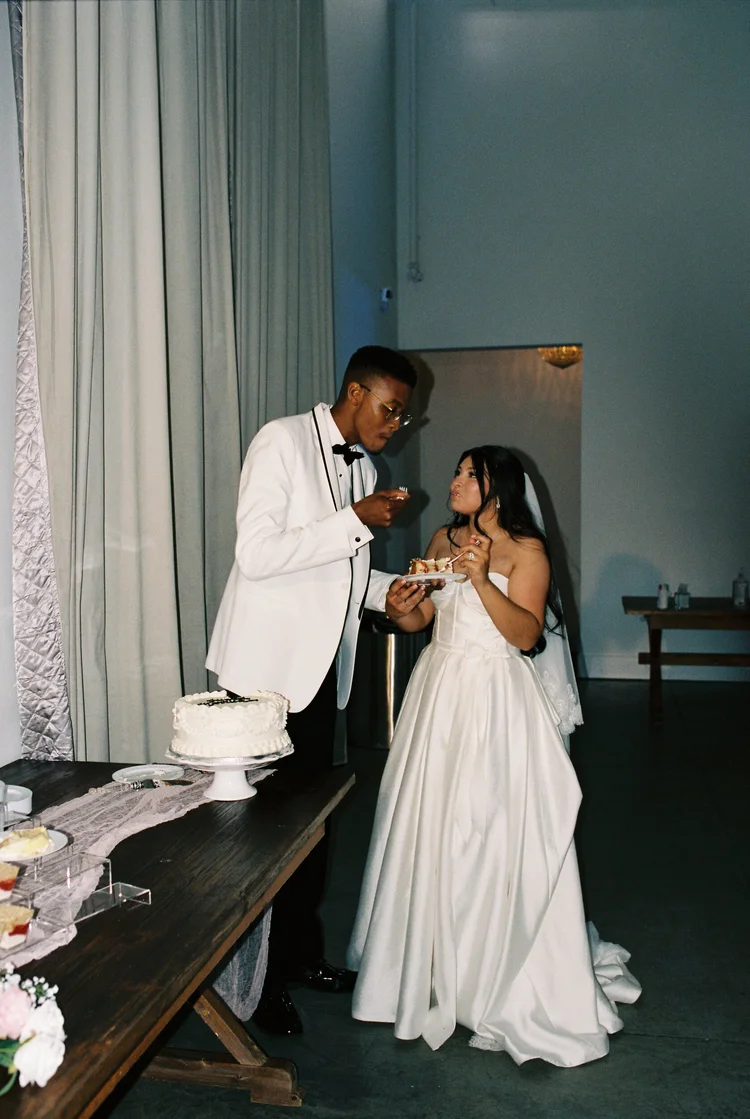A couple laughing while they cut their cake, shot on 35mm film