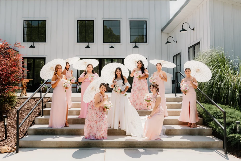 Bridesmaids under paper parasols on the steps