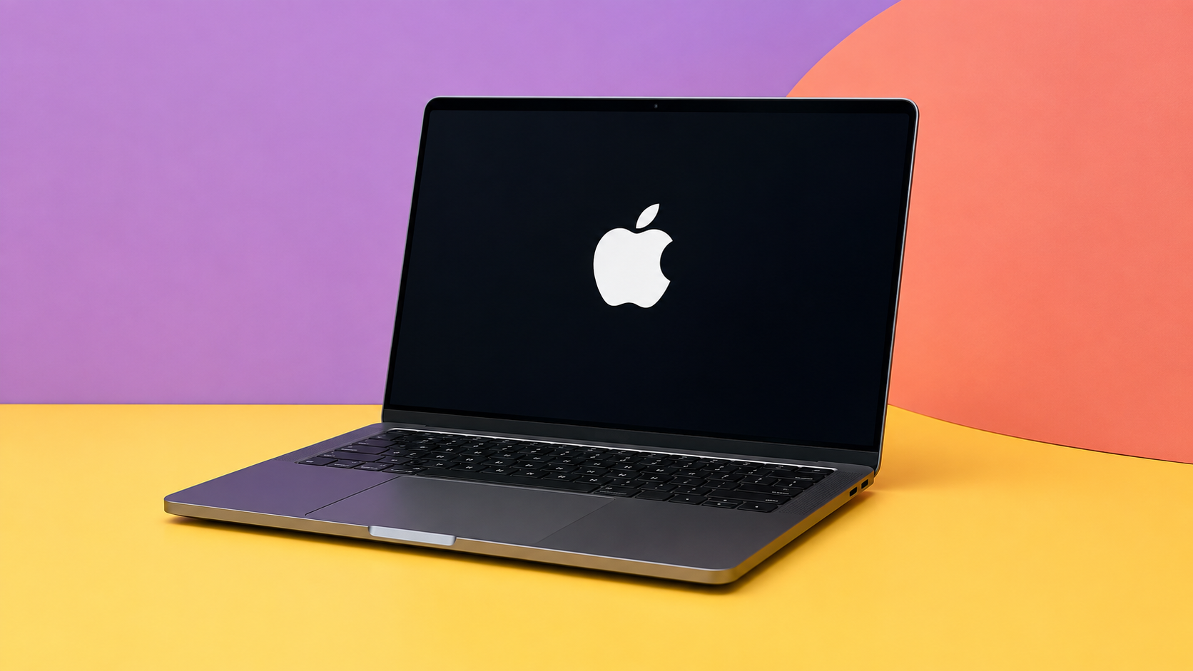 MacBook aperto frontalmente con logo Apple sul display, su sfondo a colori