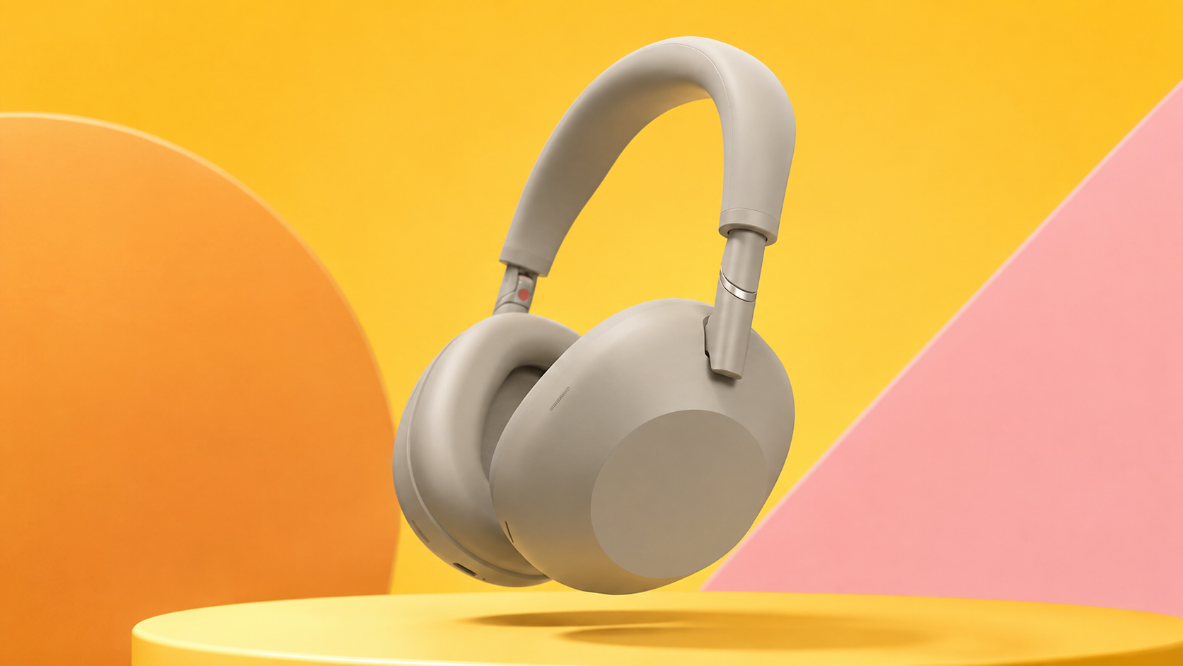 Sony WH-1000XM6 aperte su un piedistallo, con sfondo arancione e rosa