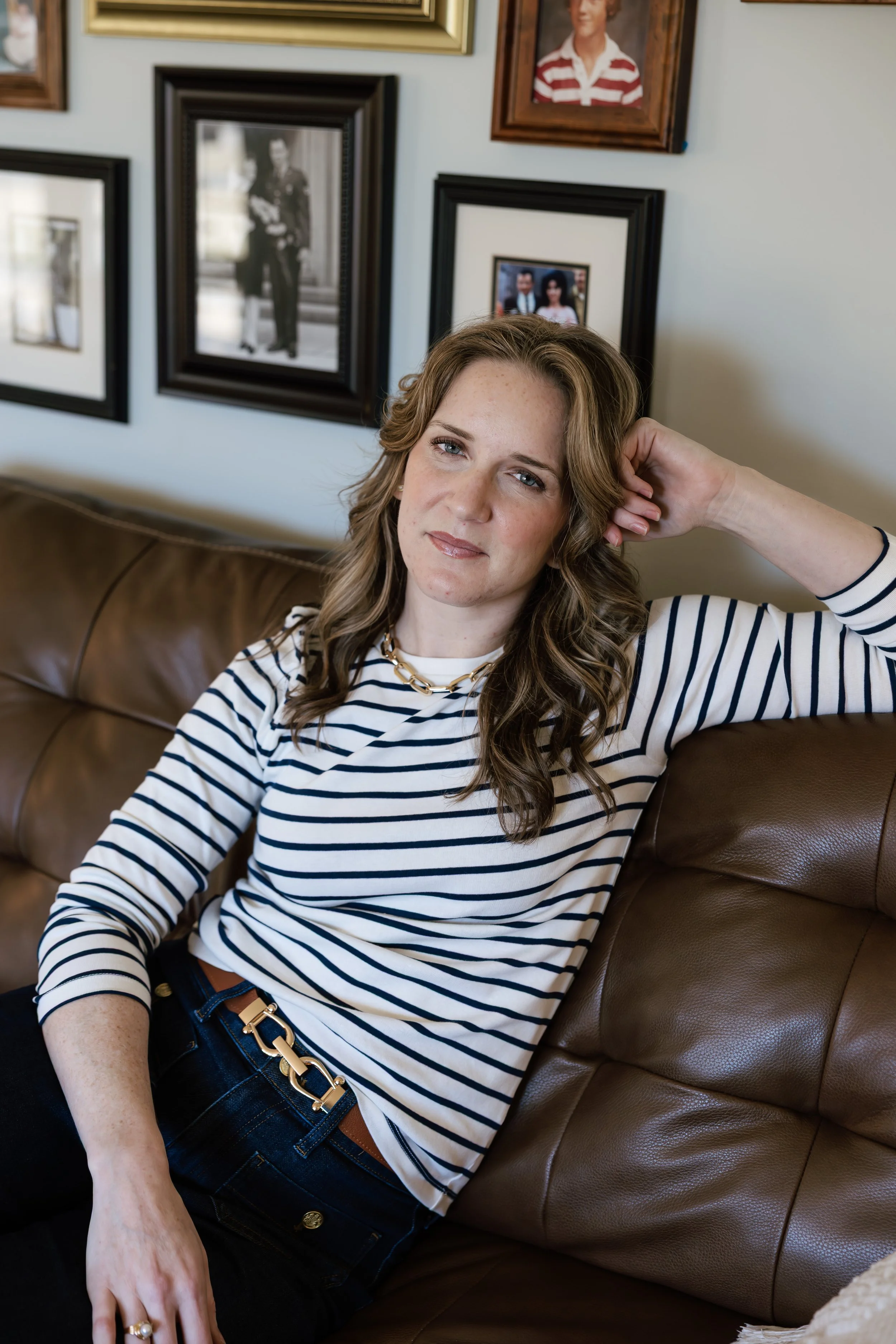 Rachel Ferrell seated on a couch in a striped shirt