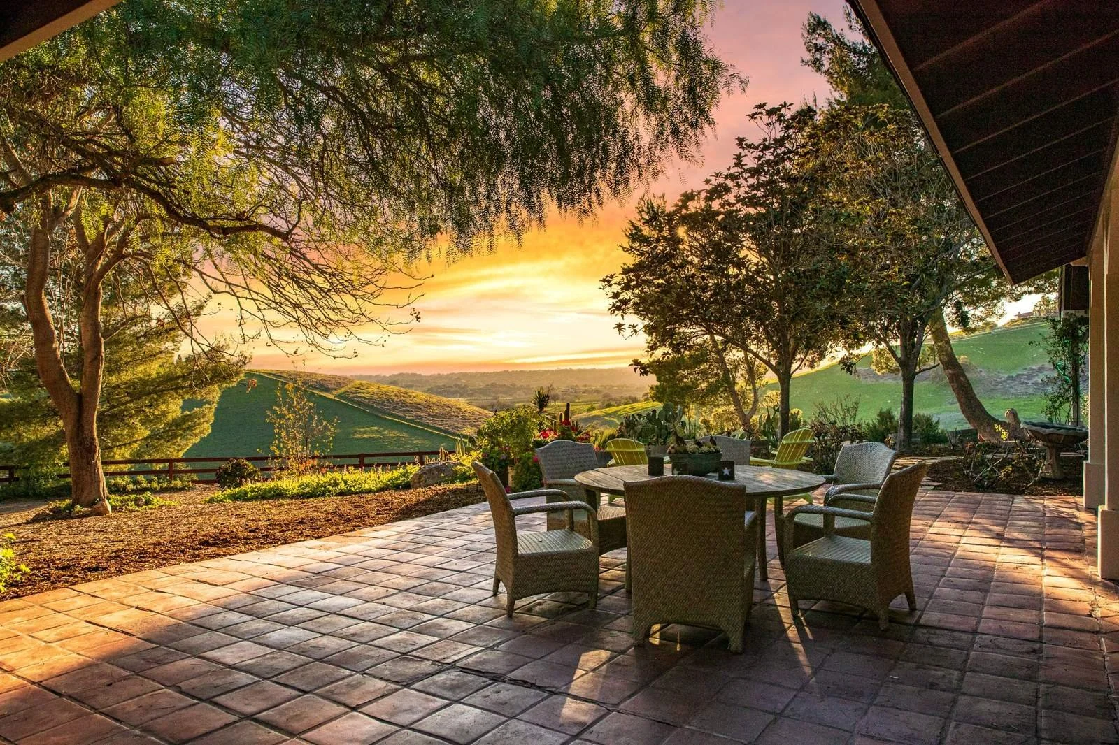 Patio table and chairs overlooking Santa Ynez Valley hills at sunset