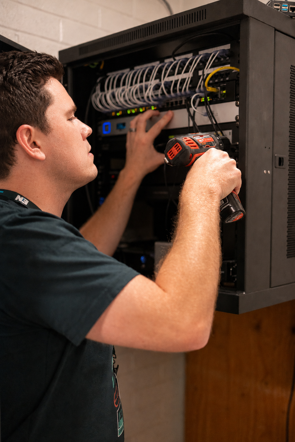A Eugene Networks engineer organizing cabling inside a network rack.