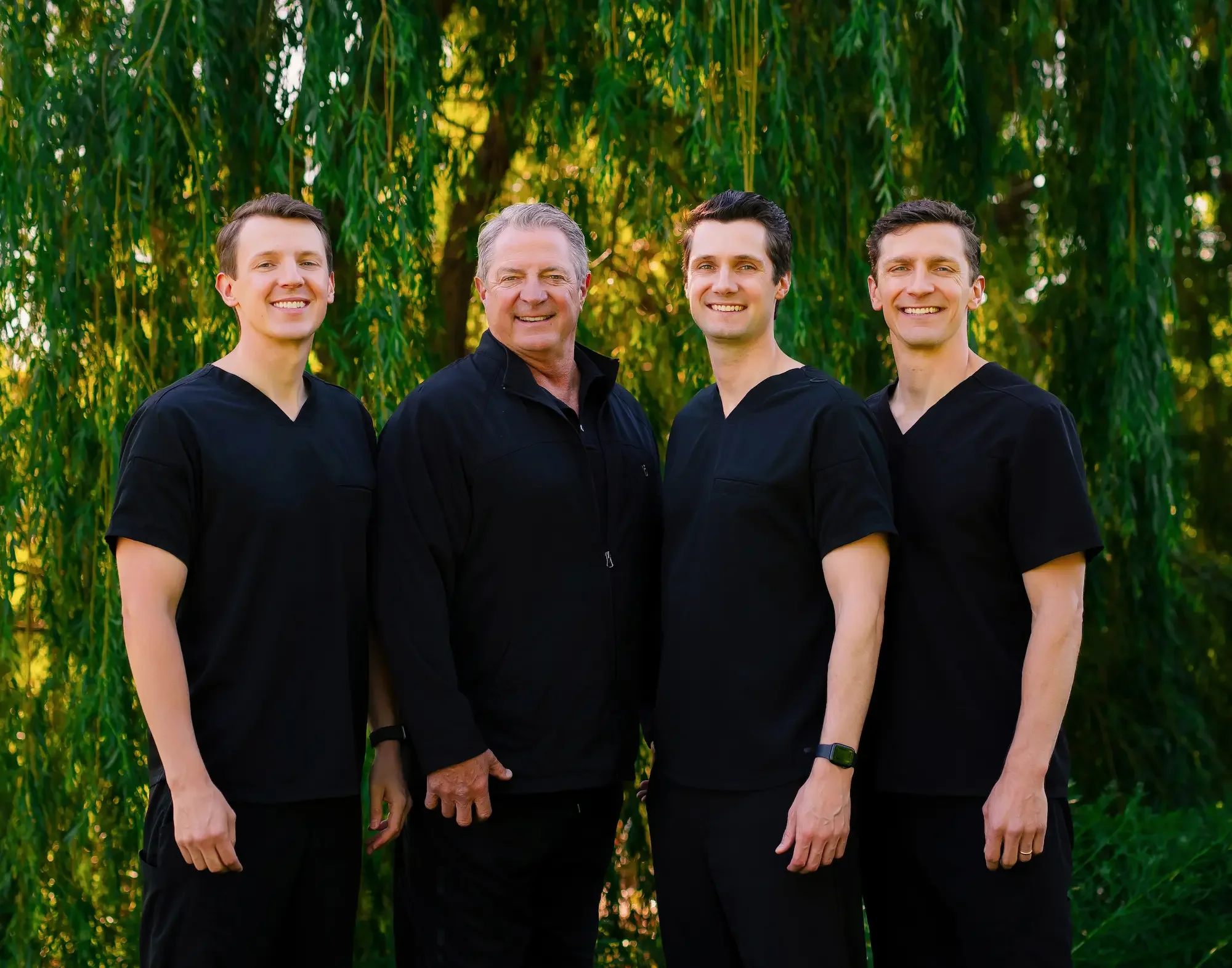Teuscher Legacy Dental doctors by a beautiful tree outside the office