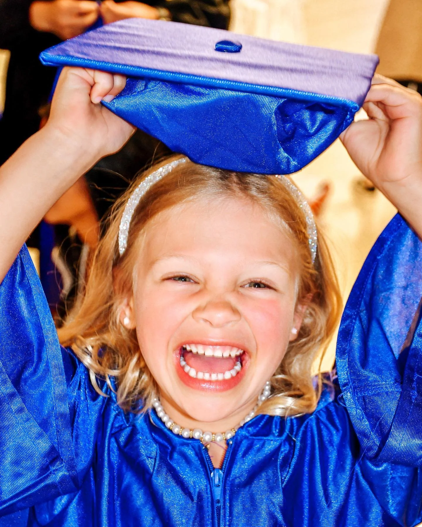 Pre-K graduate laughing in her cap and gown