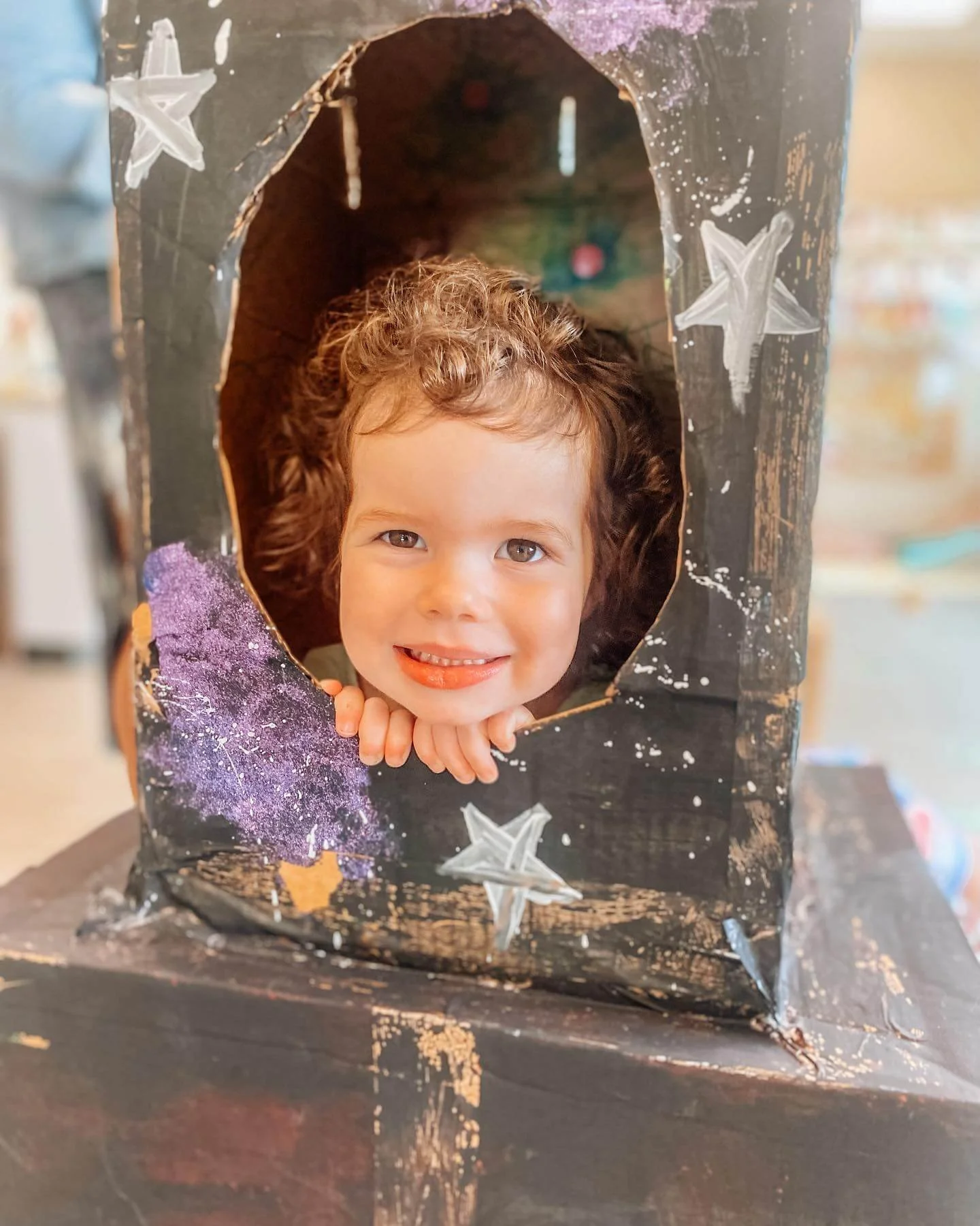 Toddlers coloring a cardboard box creation together