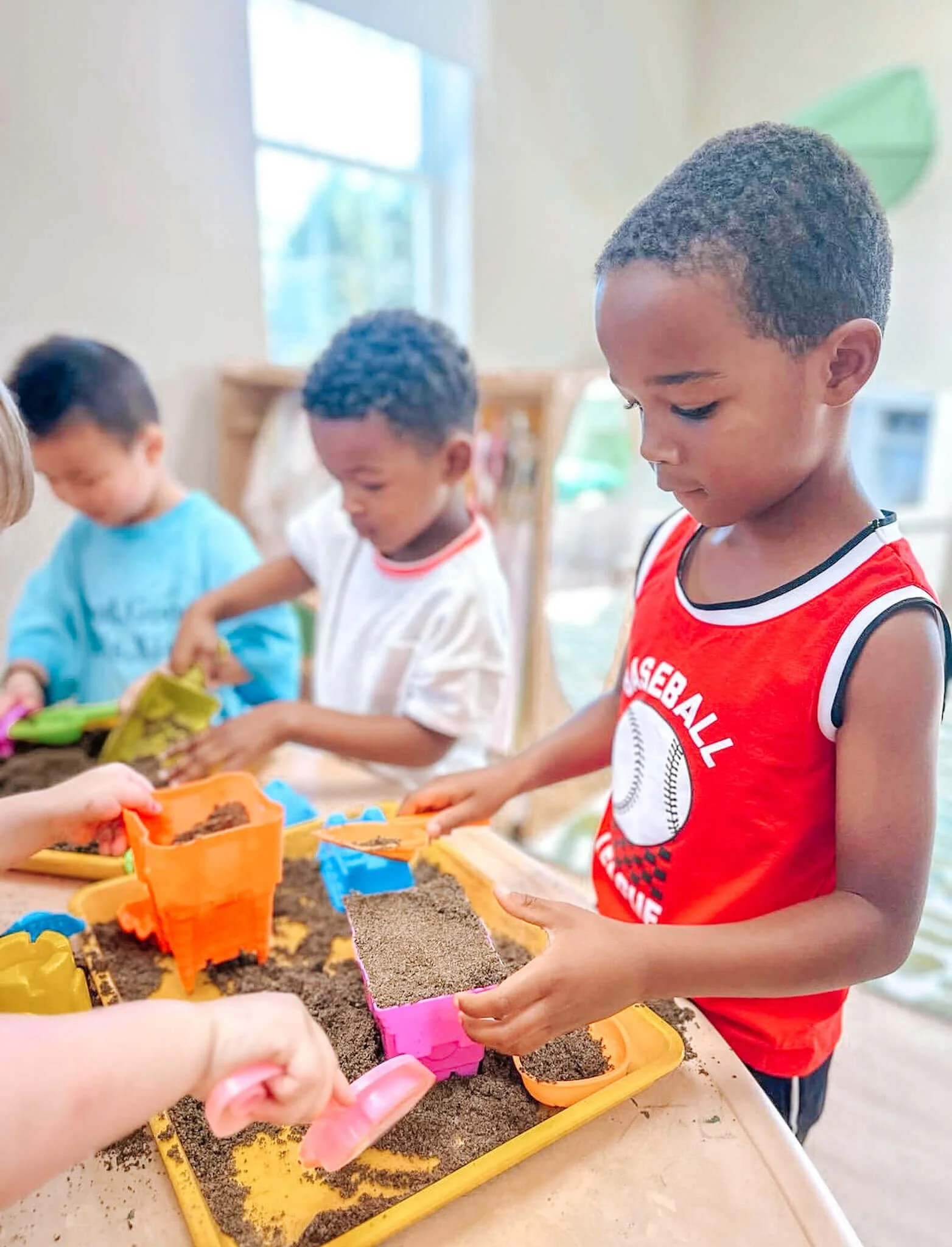 Preschoolers building with sand-castle molds
