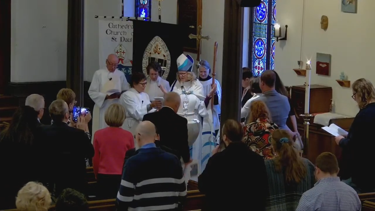 The congregation gathers with clergy around the baptismal font at St. Paul’s Cathedral.