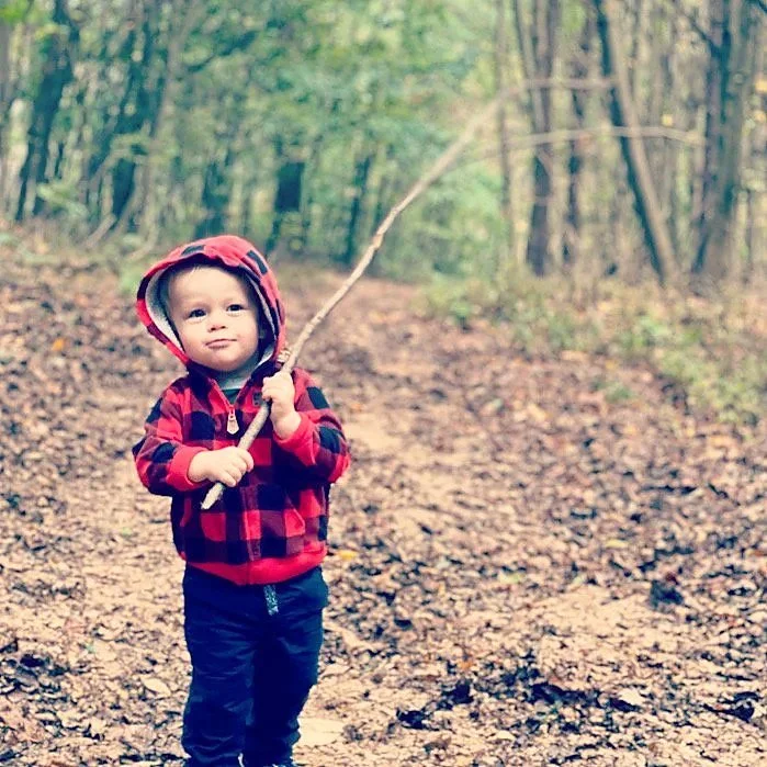 A young camper exploring the woods near the campground