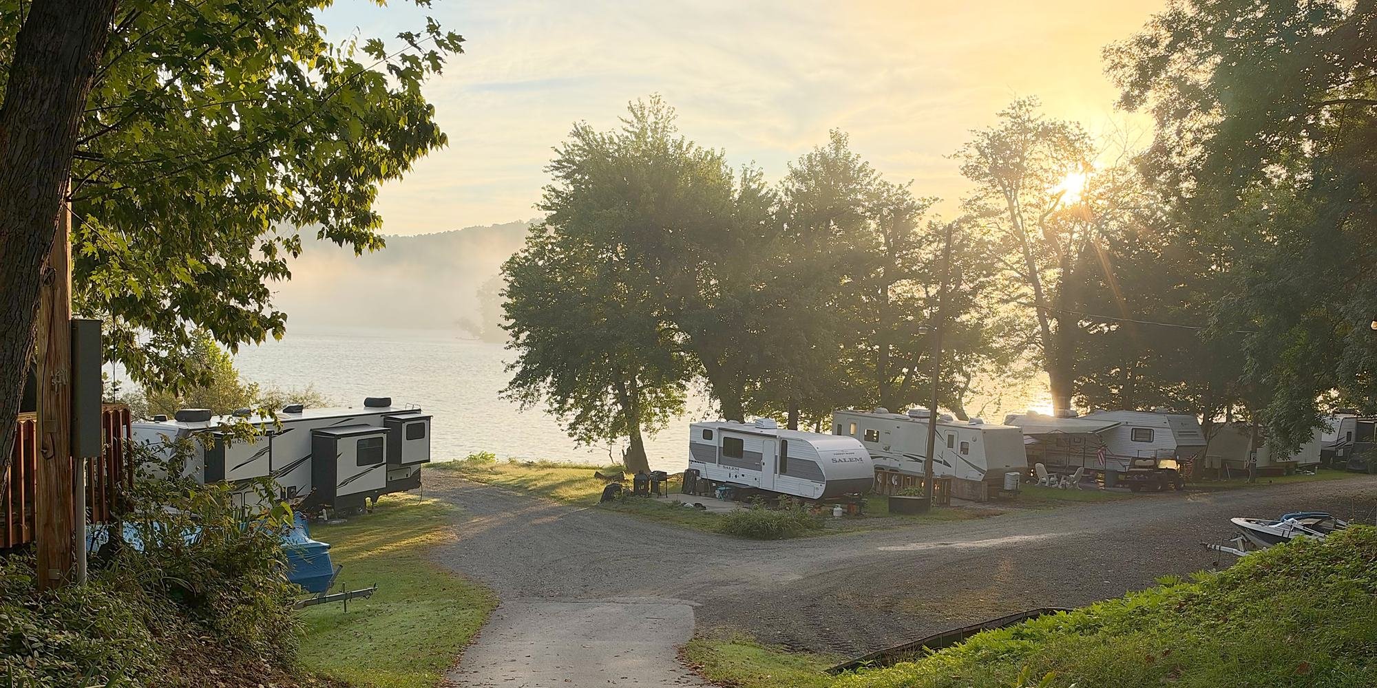 A path down to waterfront seasonal campsites, with sunrise and mist over the Susquehanna River