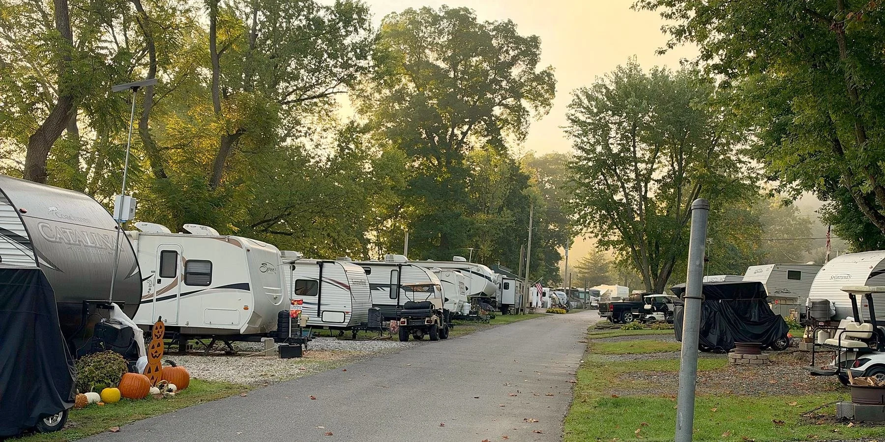 A row of seasonal campers with pumpkins on a misty morning