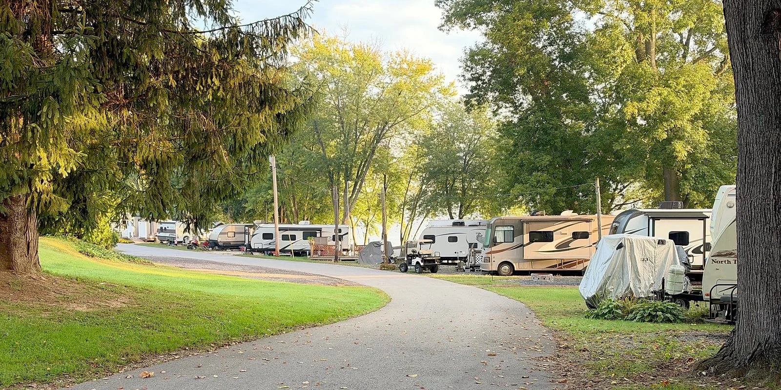A curving campground road lined with seasonal RV sites and trees