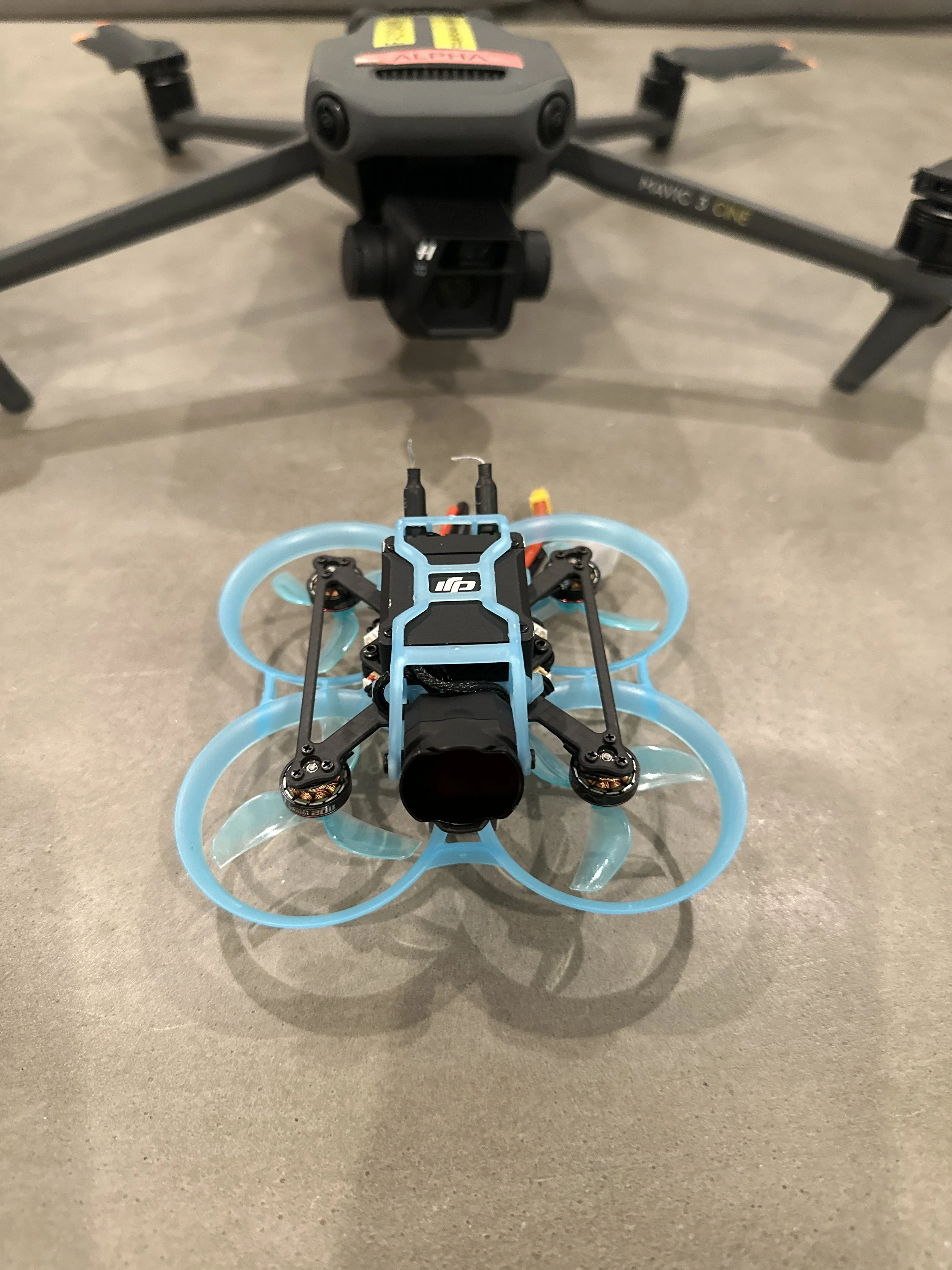 Drone Genius compact FPV drone beside a support aircraft