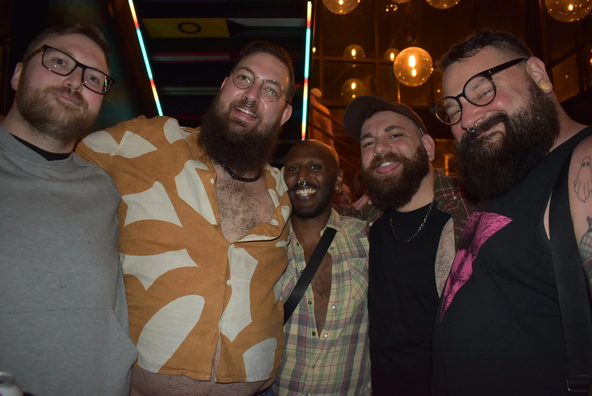 A diverse group of guests socializing and laughing at Meeting House Tavern, a queer-owned LGBTQ+ bar in Andersonville, Chicago