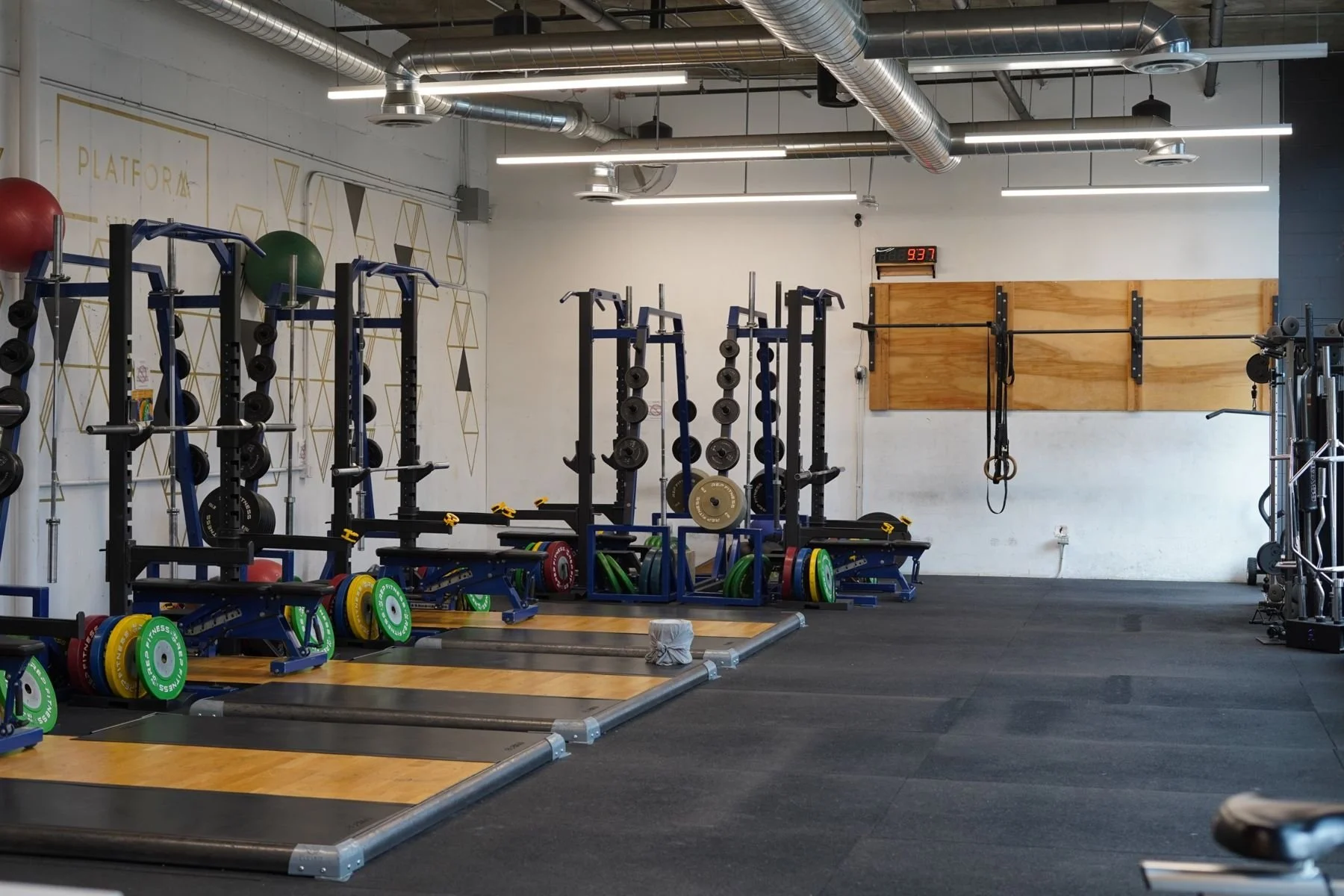The open gym floor with squat racks, platforms and a pull-up rig