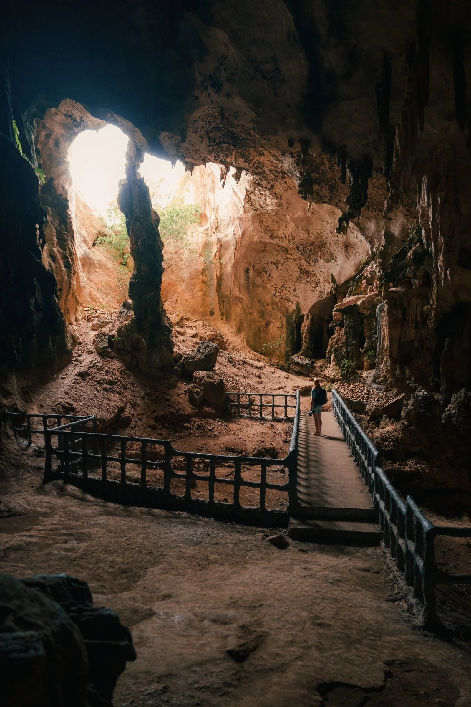 Traveller exploring a vast illuminated cave in Thailand