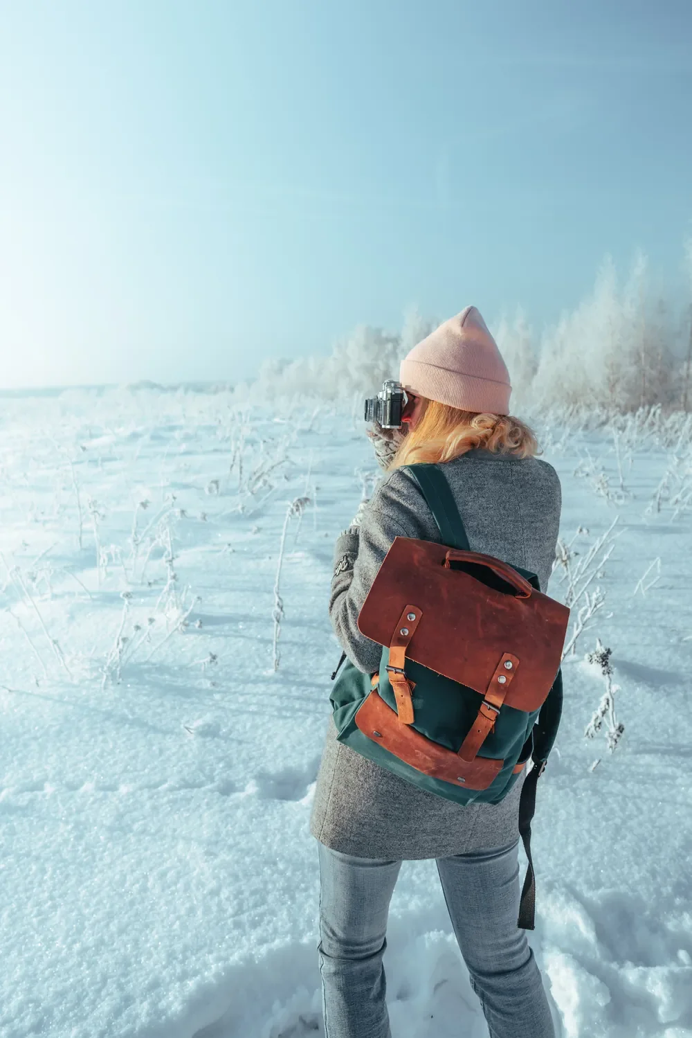 Woman wearing a Wildbags backpack in a snowy field