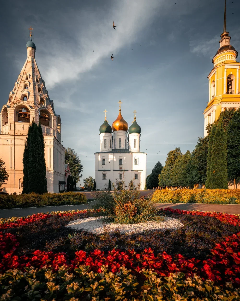 Historic cathedral and garden under a dramatic sky