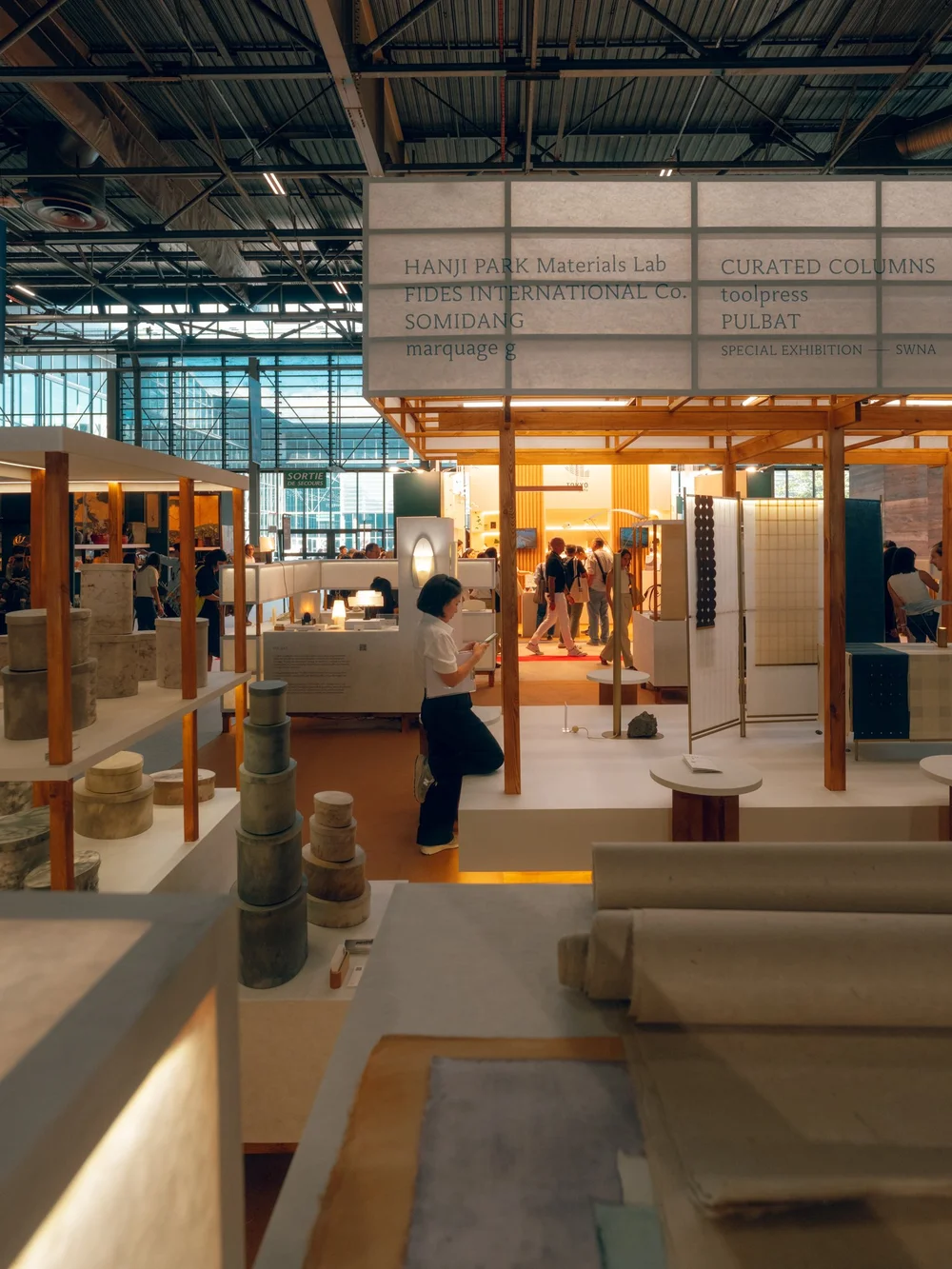 Visitors exploring the paper displays inside the HANJI HOUSE pavilion