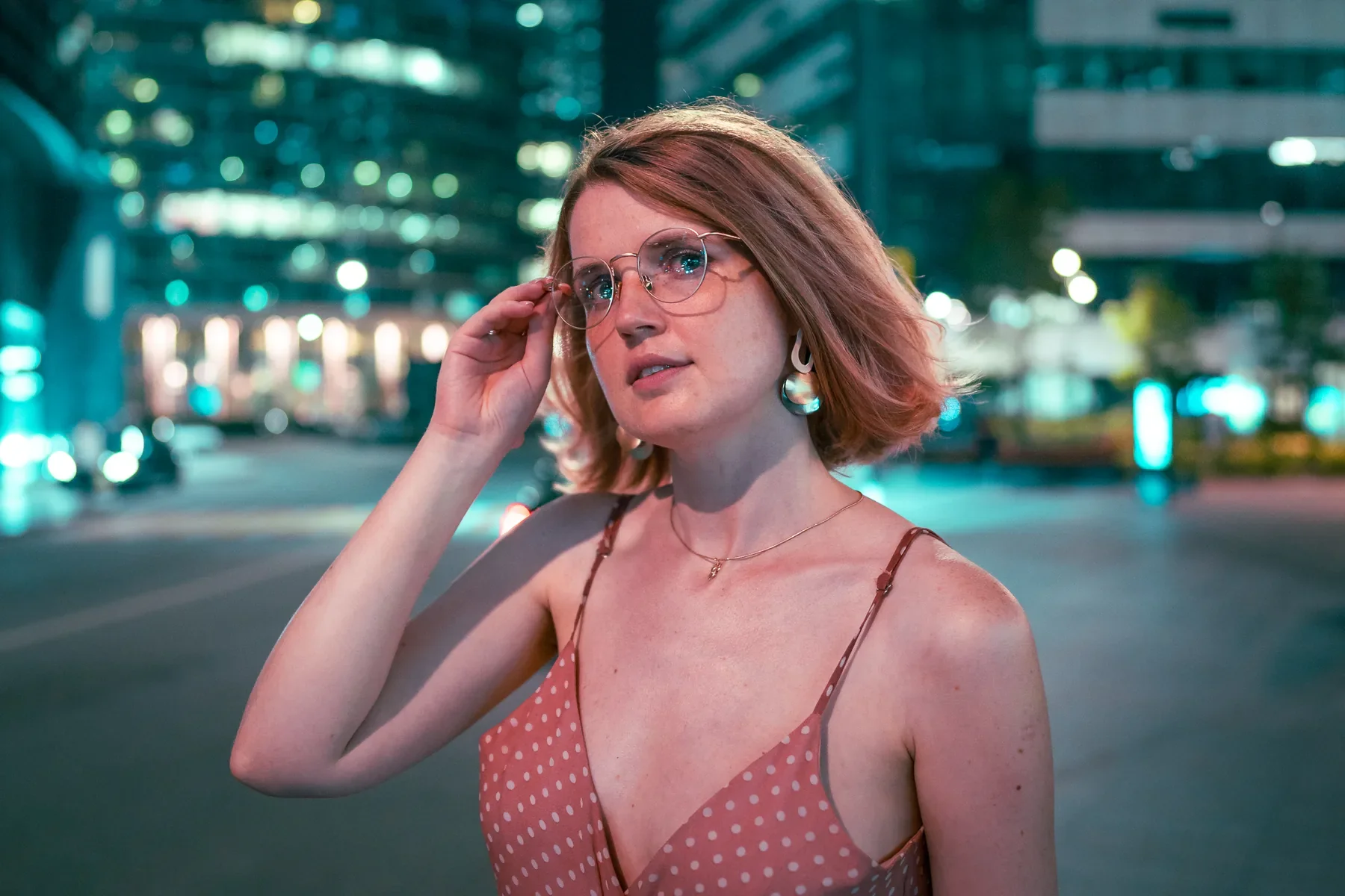 Woman wearing TIJN glasses on a city street at night