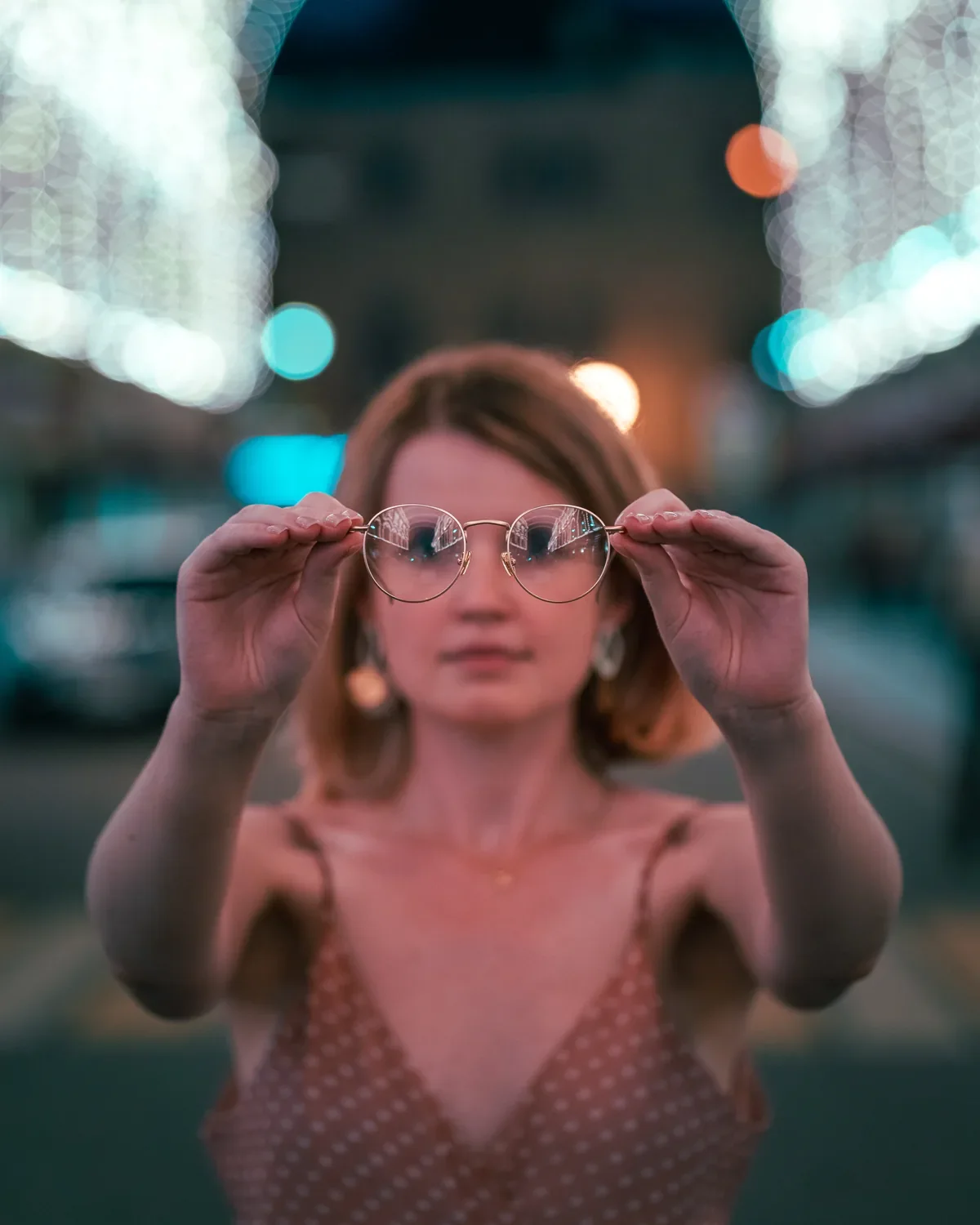 Woman holding TIJN glasses toward the camera