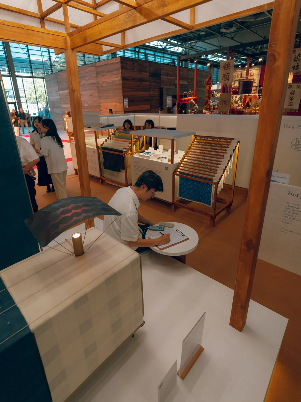 Paper objects and fans displayed inside the warm timber exhibition space