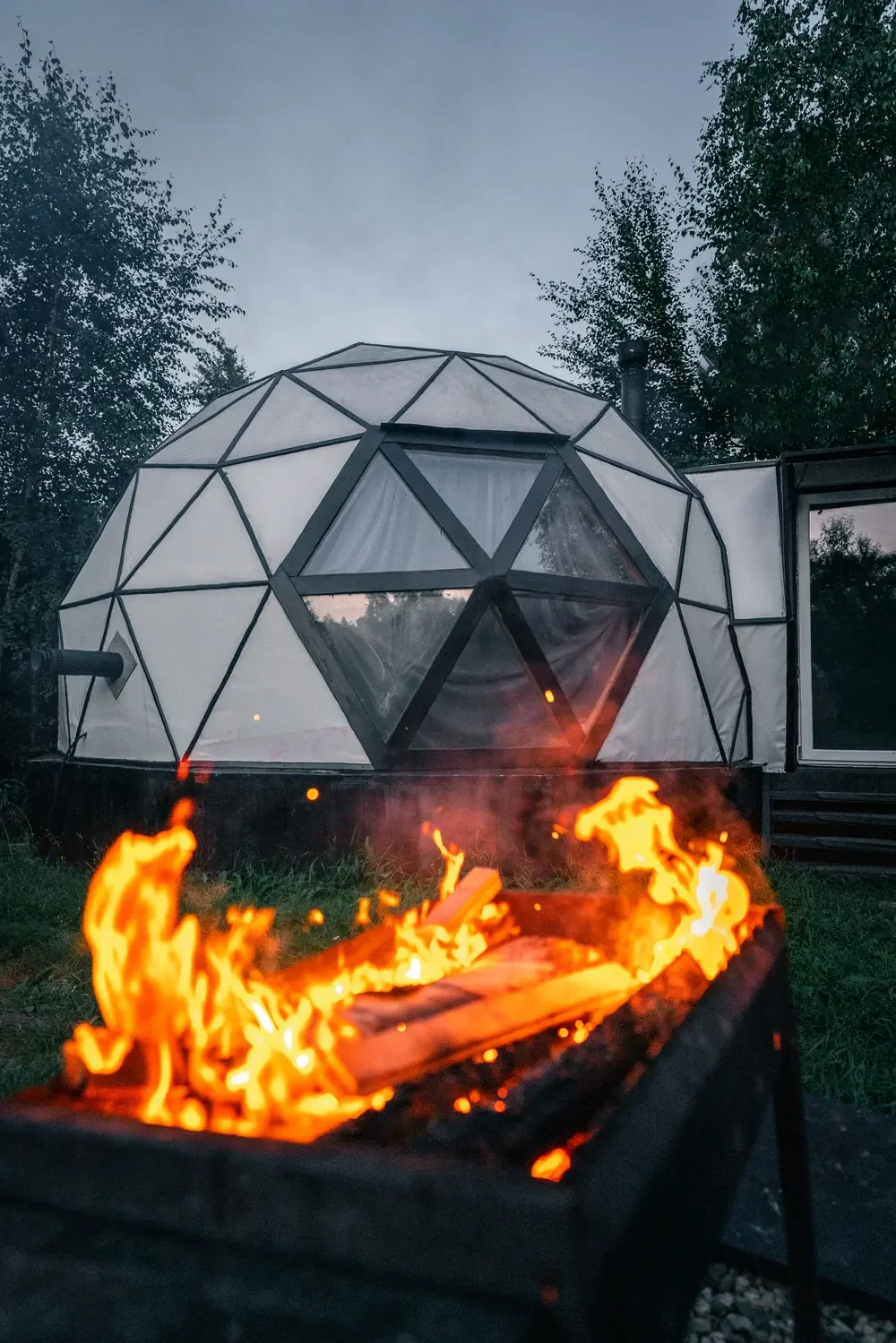 Campfire burning in front of a geodesic dome