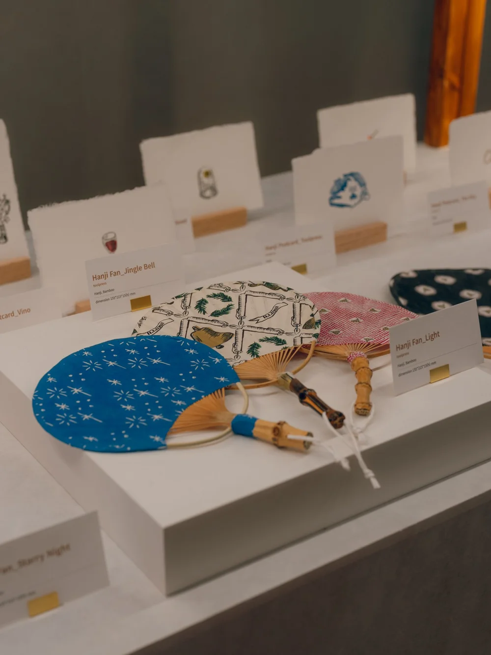 Blue and patterned paper fans presented alongside small craft objects